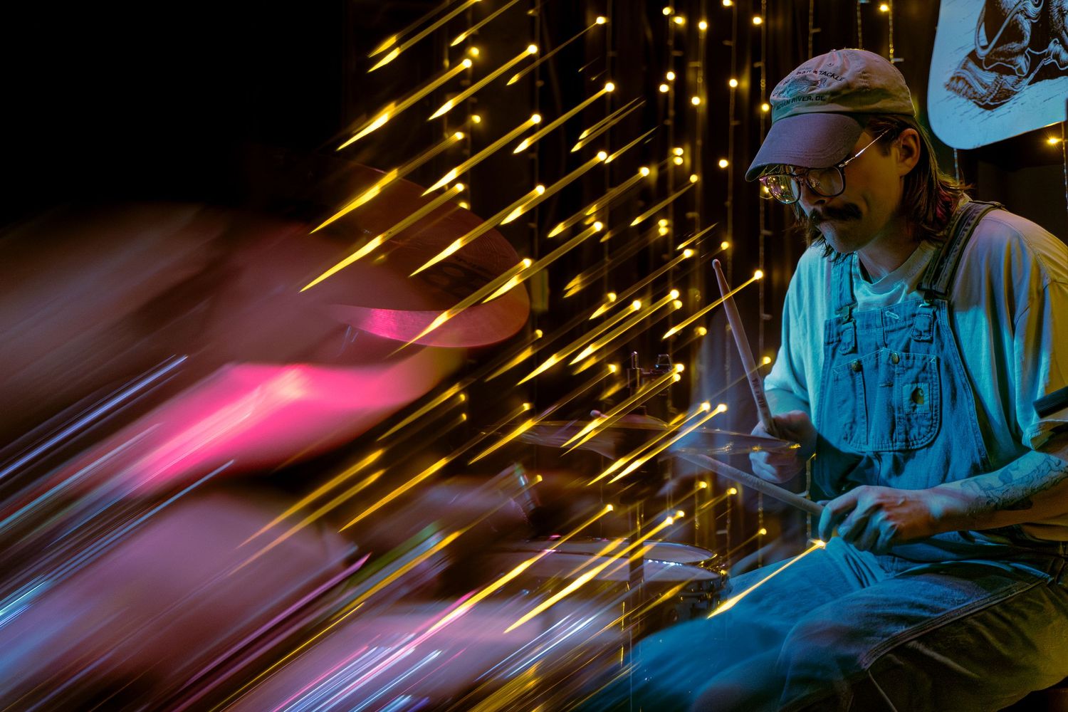 Neon streaks of pink and blue light create a glowing motion blur effect against a dark background.