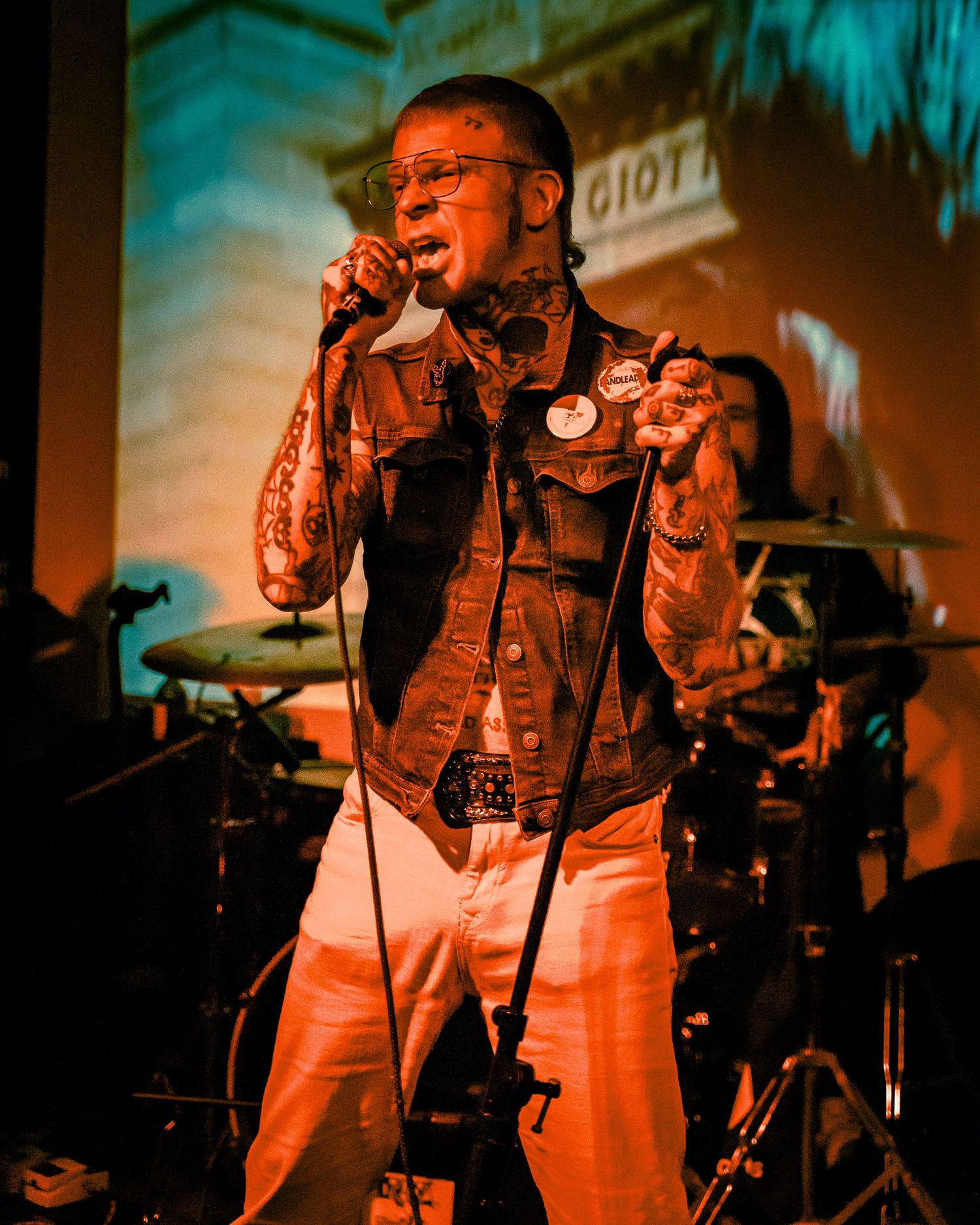 Musicians performing on stage under warm orange theatrical lighting.