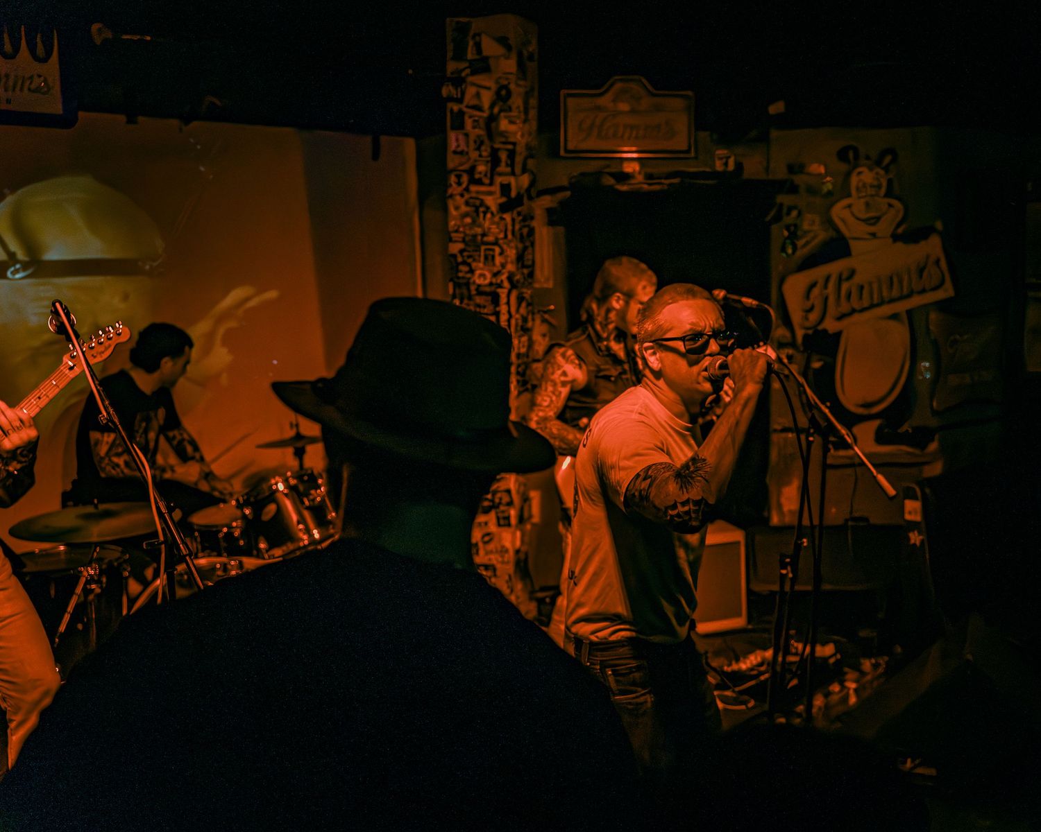 Dark concert venue with musicians performing under dim atmospheric lighting.