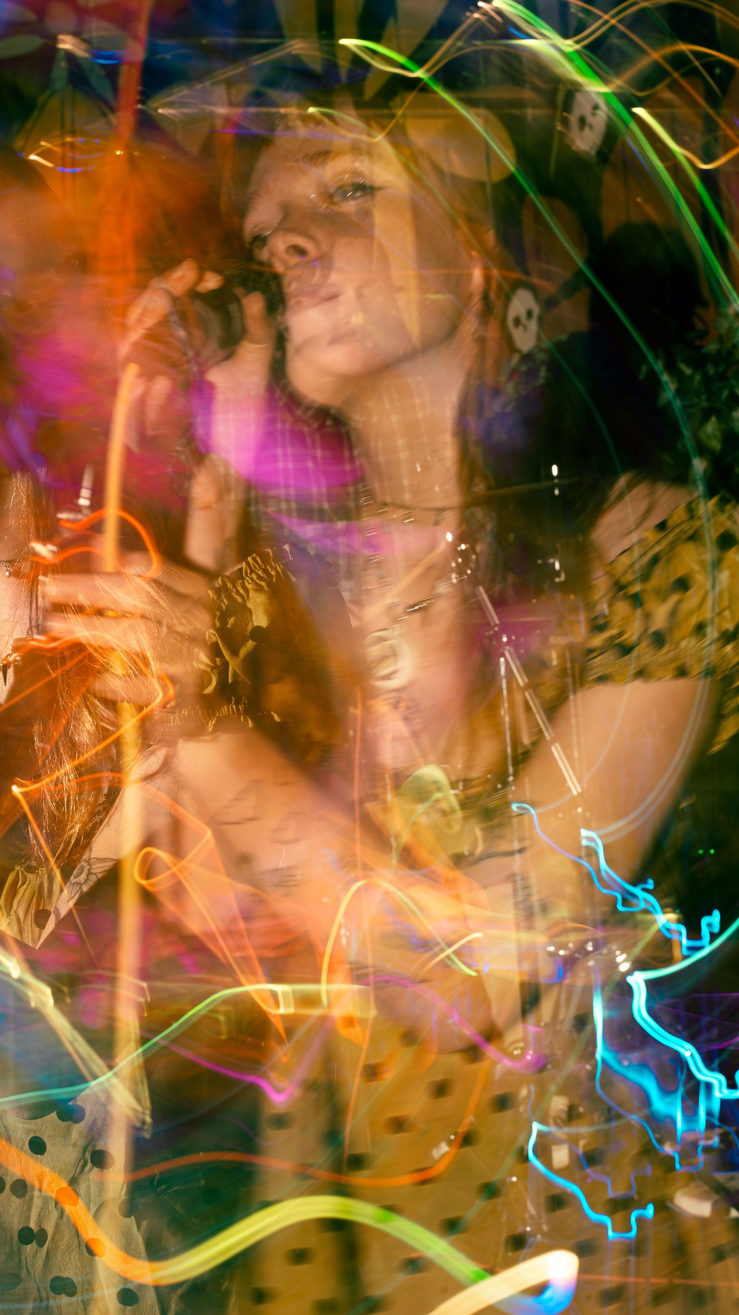 Long exposure concert photo with colorful light trails and motion blur effects.