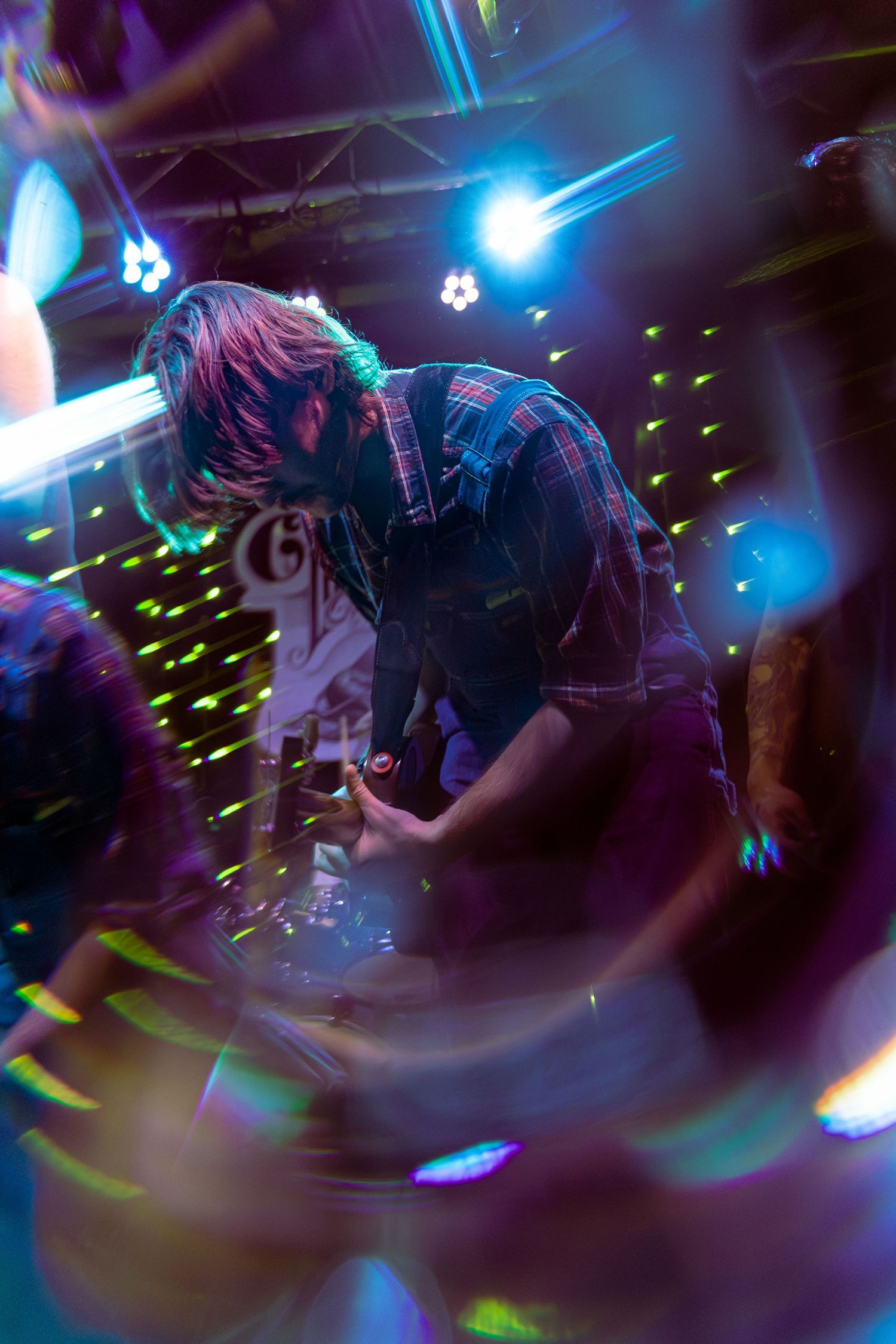 Dancing in a nightclub with blue stage lights and green laser effects creating an energetic atmosphere.