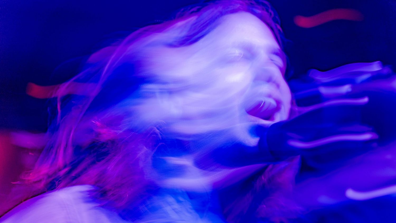 Abstract blue motion blur photography capturing performer movement on stage.