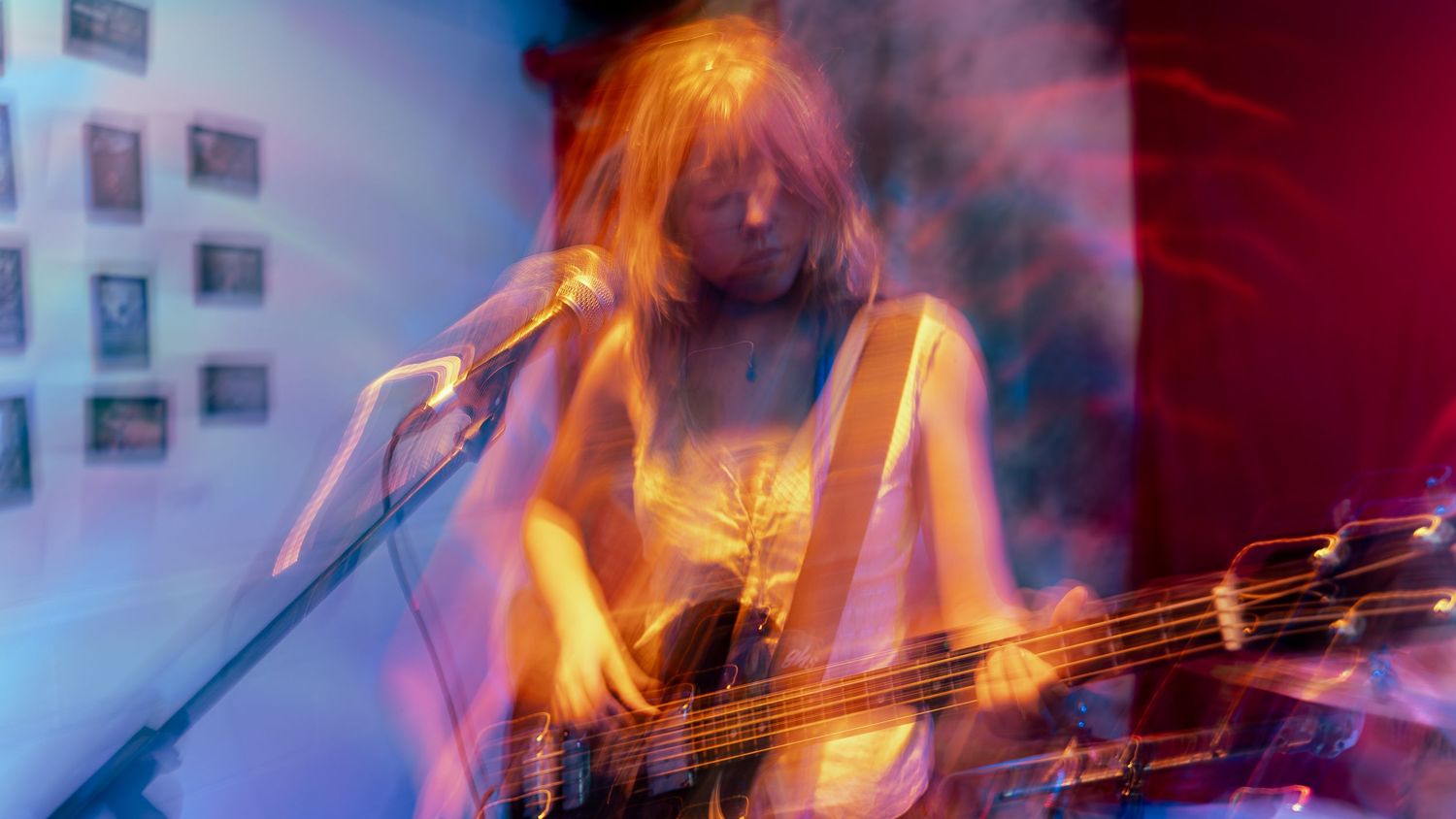 Motion-blurred abstract image showing dynamic movement in orange and purple tones against a dark background.