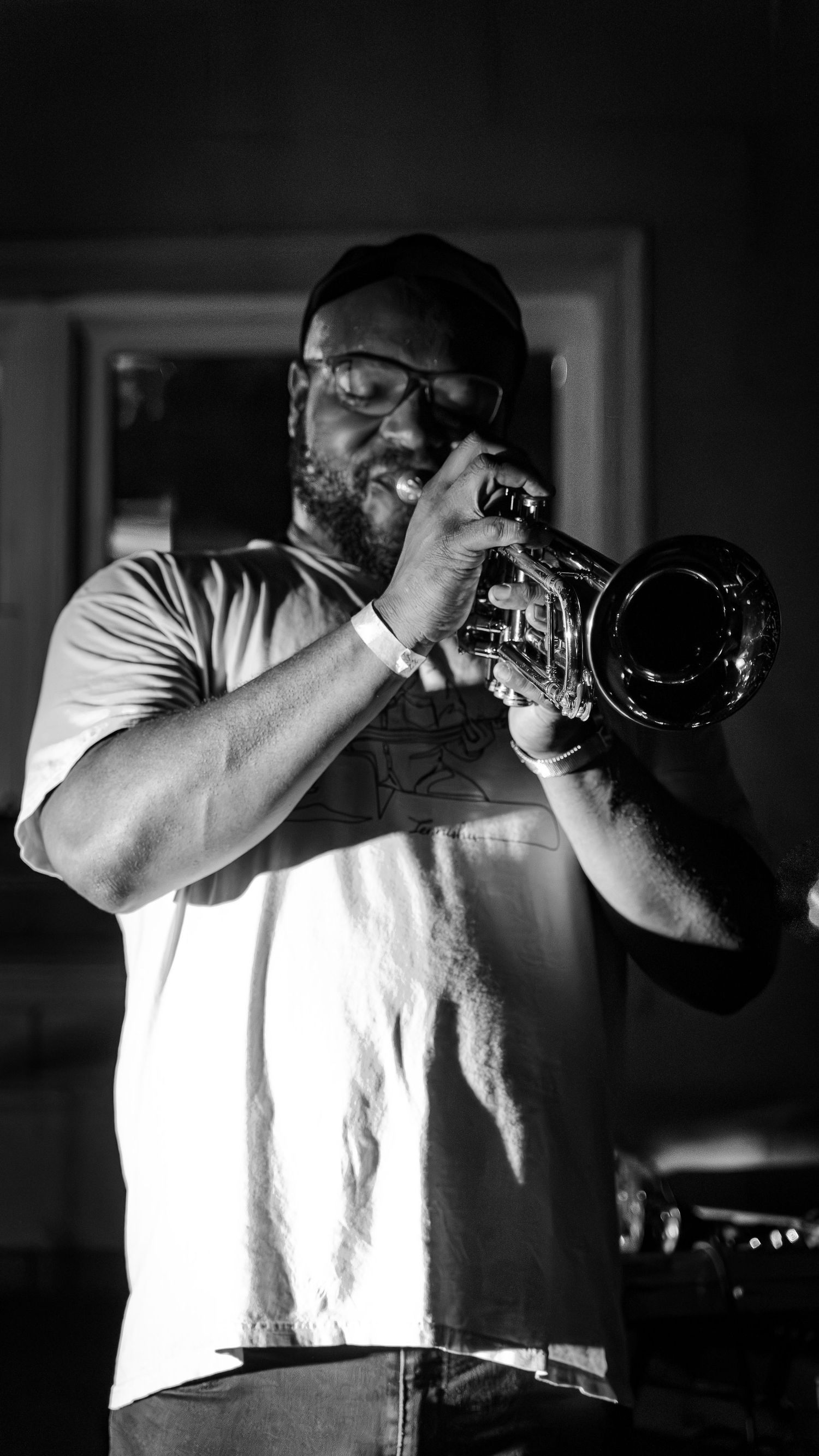 Black and white shot of performer with camera creating dramatic contrast.