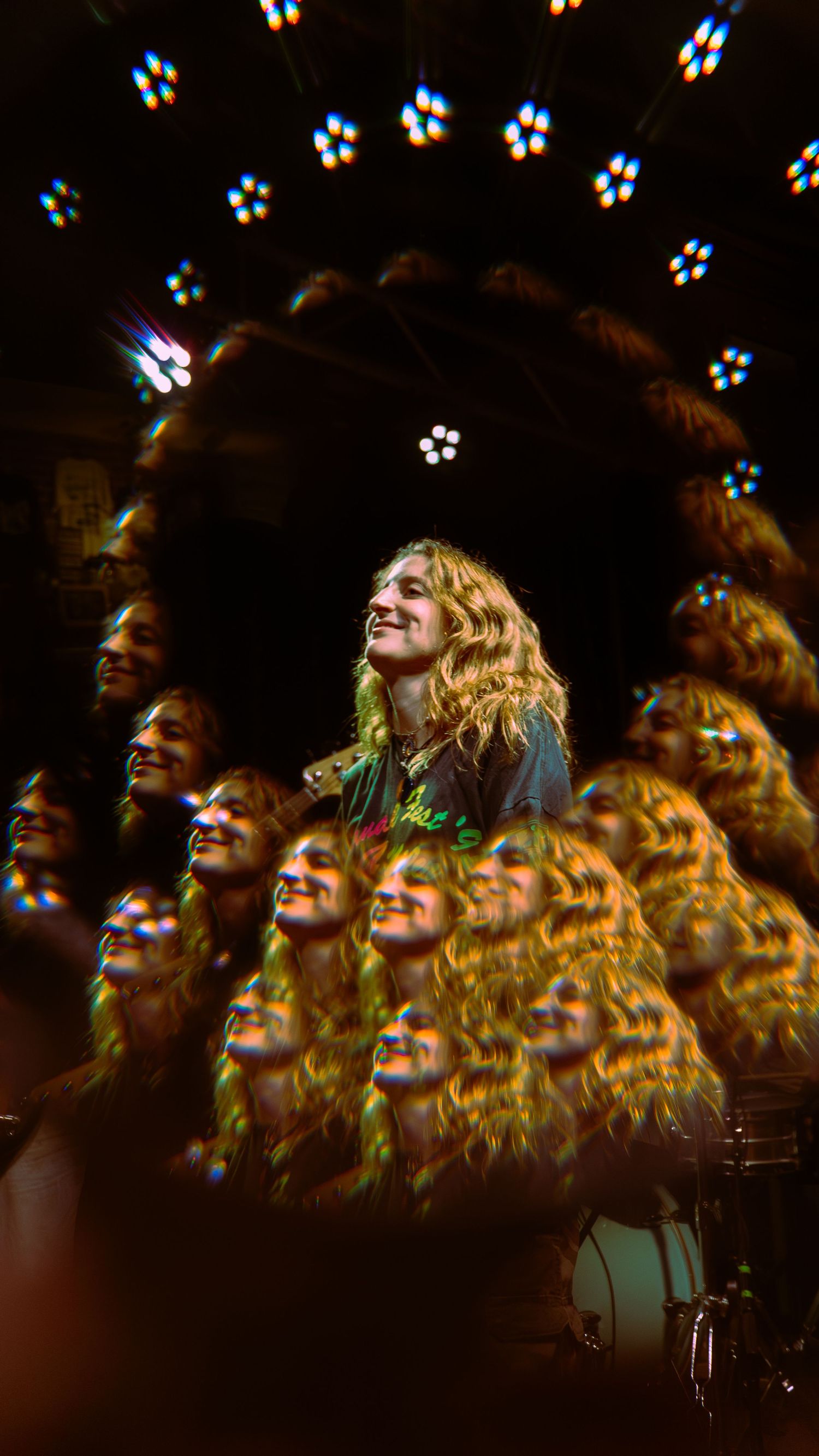 Artistic multiple exposure photograph showing cascading reflections with bokeh lights scattered against dark background.