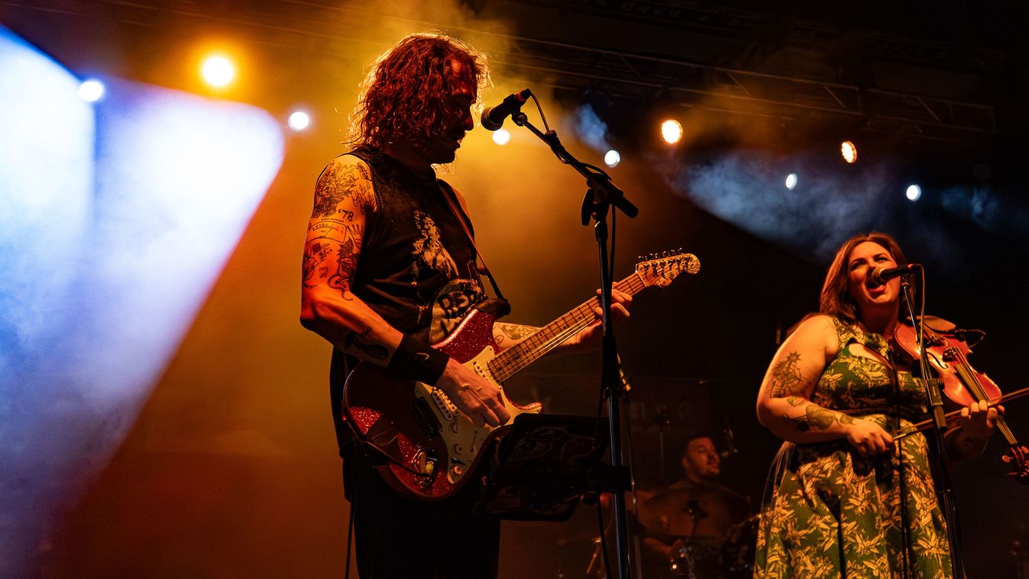Concert performance captured with dynamic lighting and silhouetted musicians on stage.