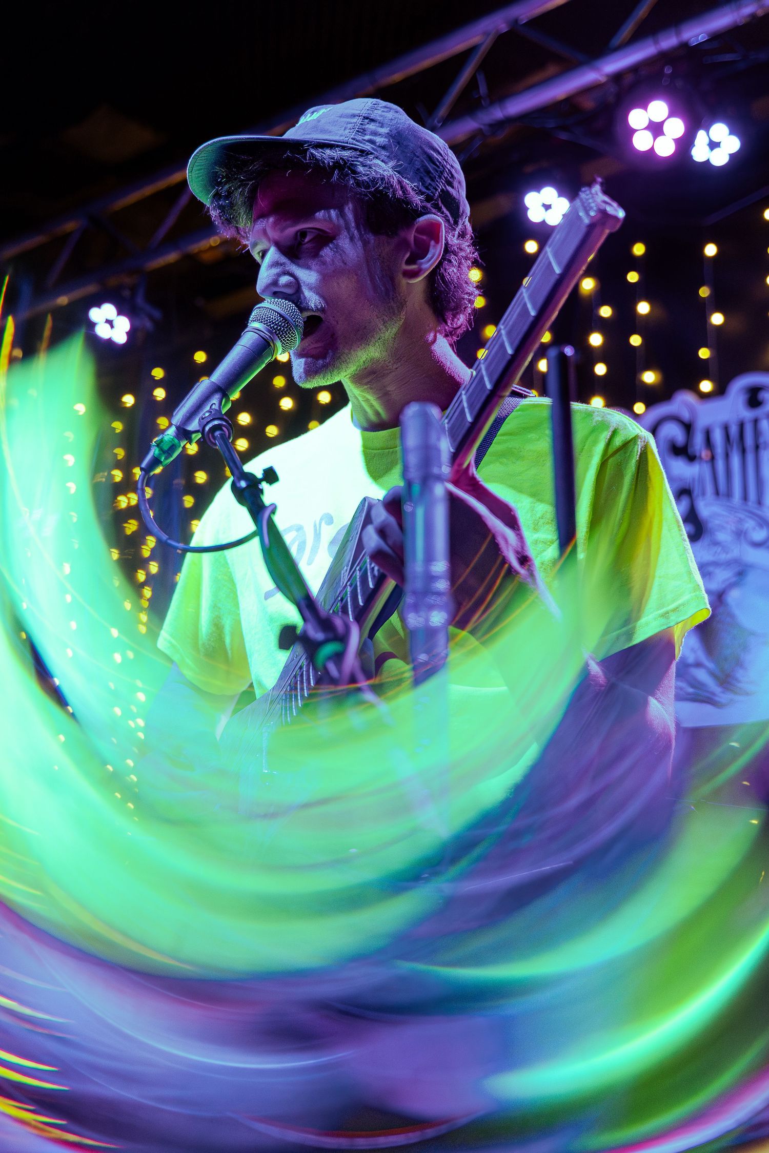 Multiple exposure sequence shows colorful swirling motion of performers on stage with purple and green lighting effects.