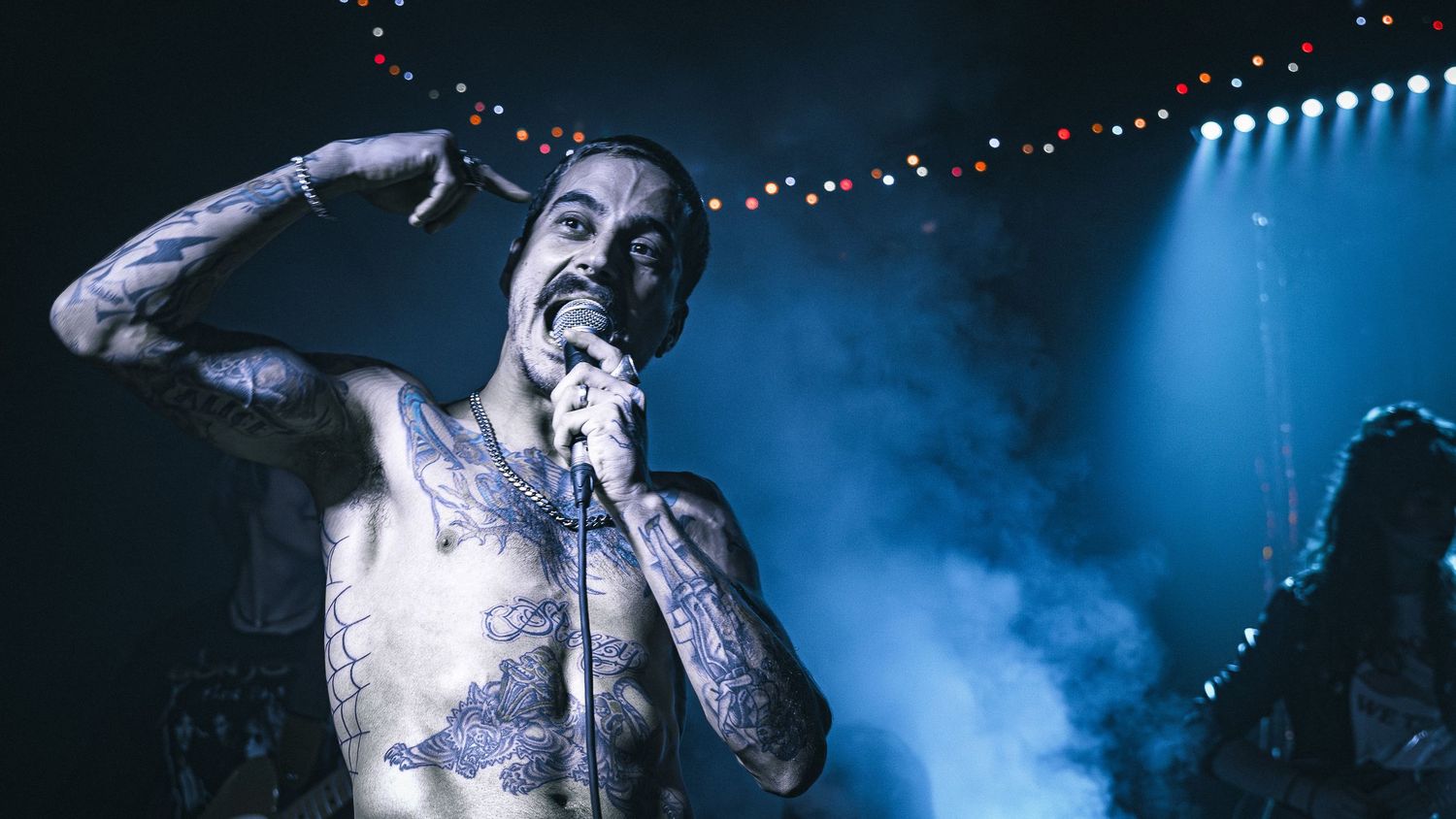 Stage performance with atmospheric blue lighting and smoke effects.