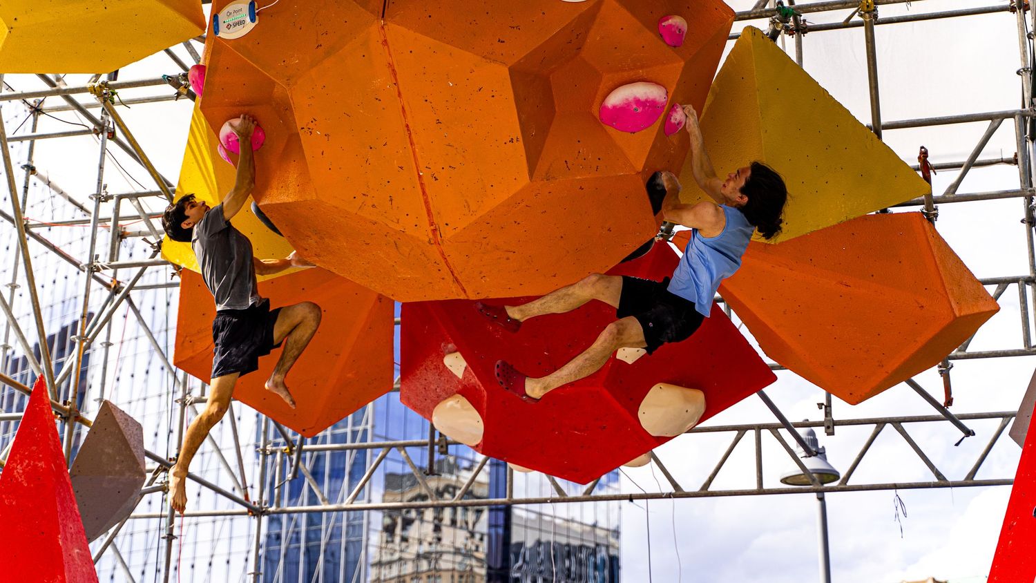 Orange and yellow umbrellas create artistic ceiling installation in urban space.