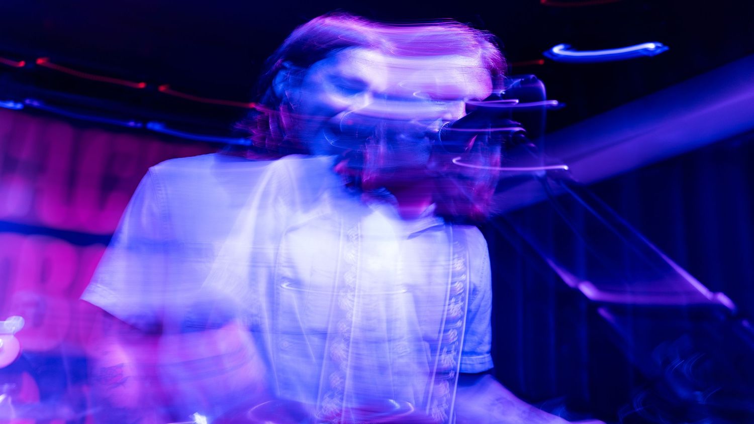 Motion-blurred concert photo with blue lighting creating an ethereal performance atmosphere.