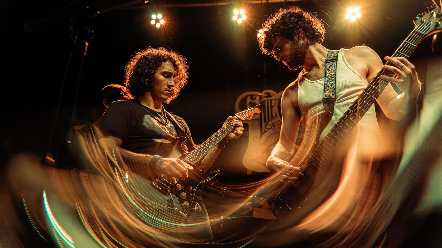Concert performers playing musical instruments on stage with dramatic lighting and motion blur effects.
