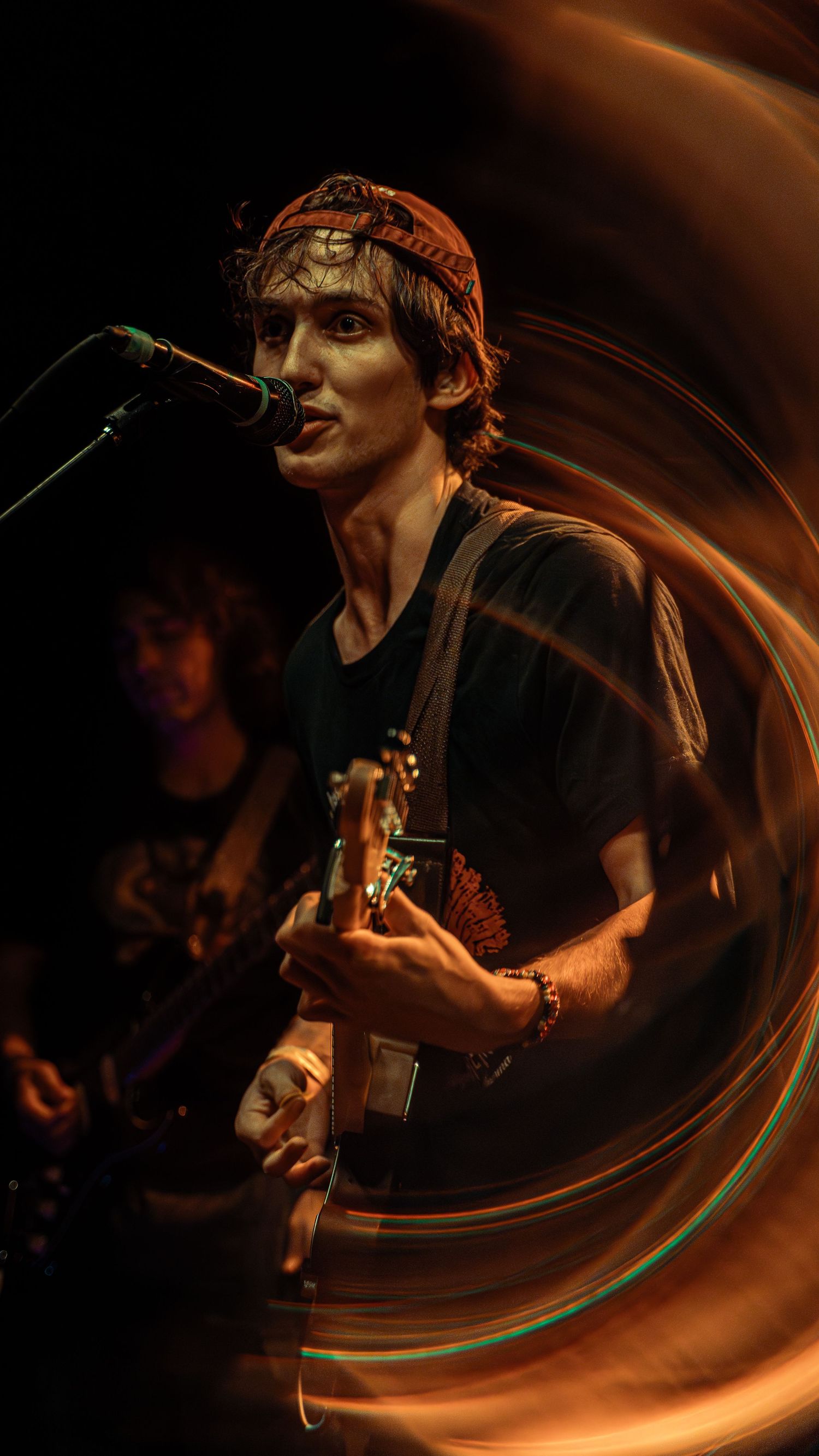 Motion blur effect creates a dynamic scene of a musician performing on stage in dramatic lighting.