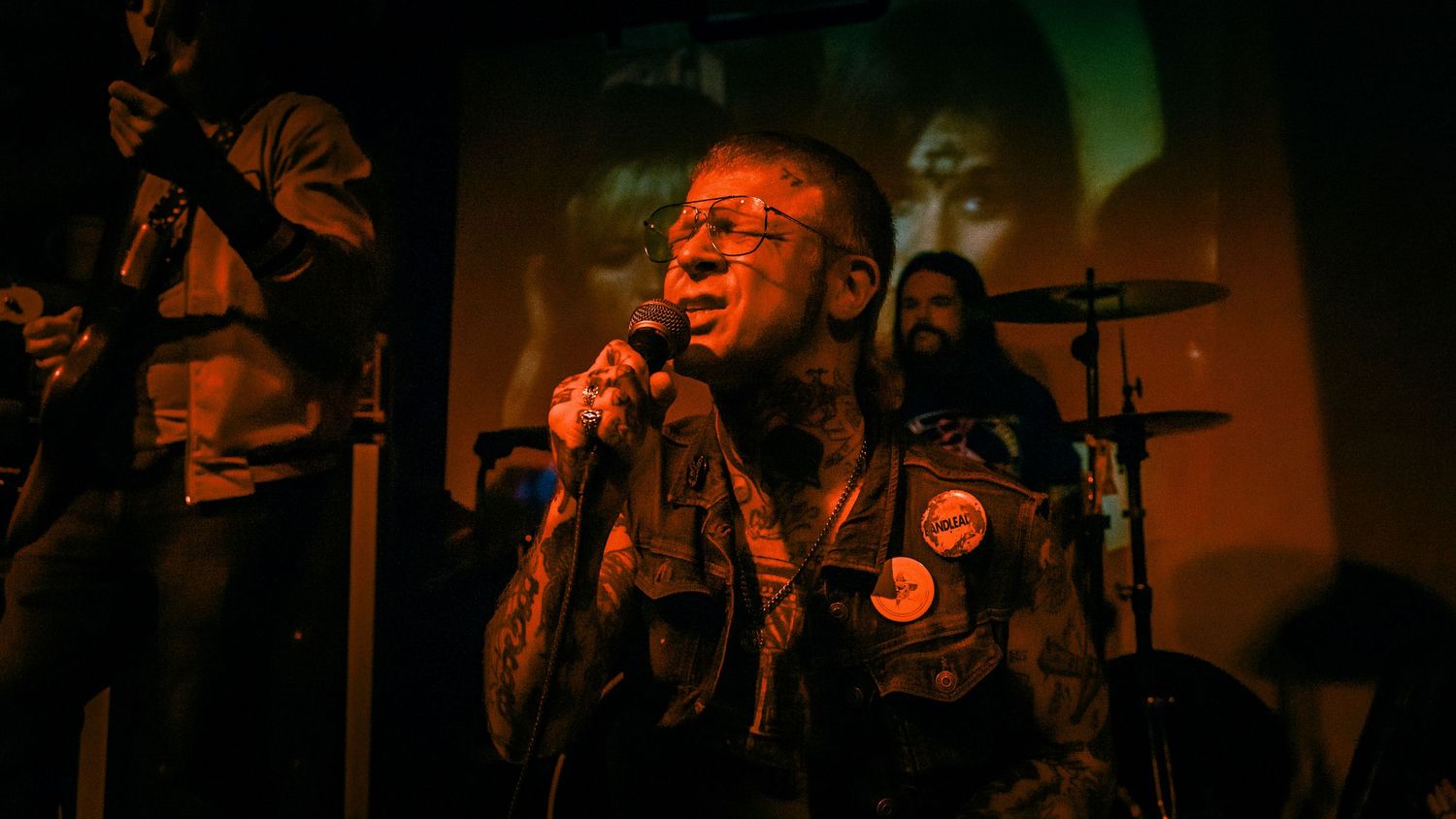Rock performance captured in dramatic green and orange stage lighting.