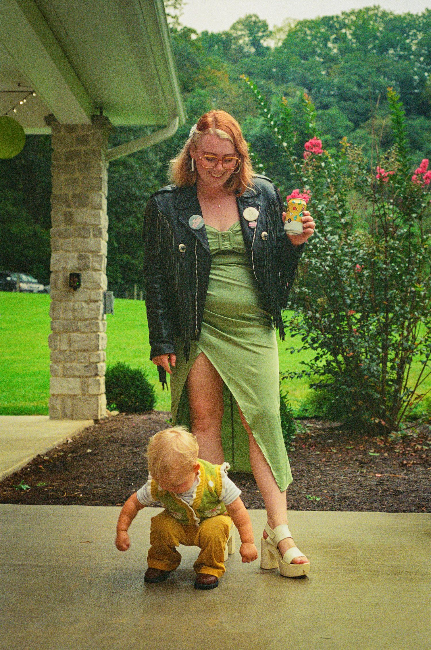 A sequence showing someone crawling on a concrete path near landscaped gardens and pillars.