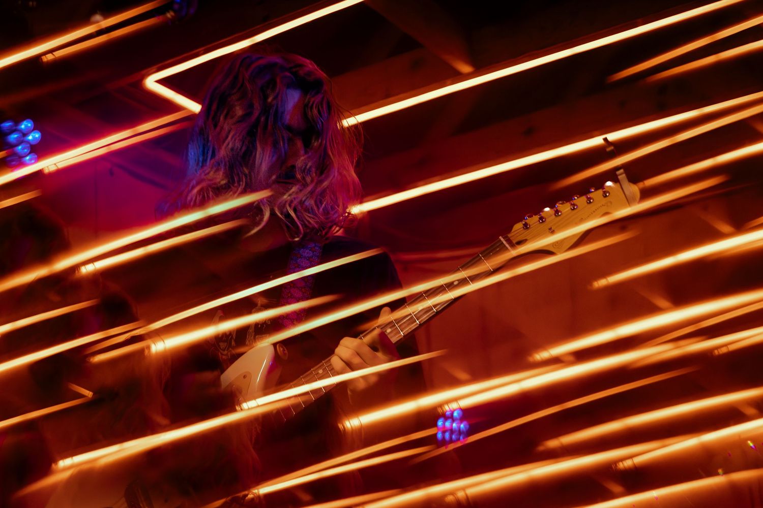 Abstract light trails and motion blur create dynamic streaks of orange against dark background in nighttime photography.