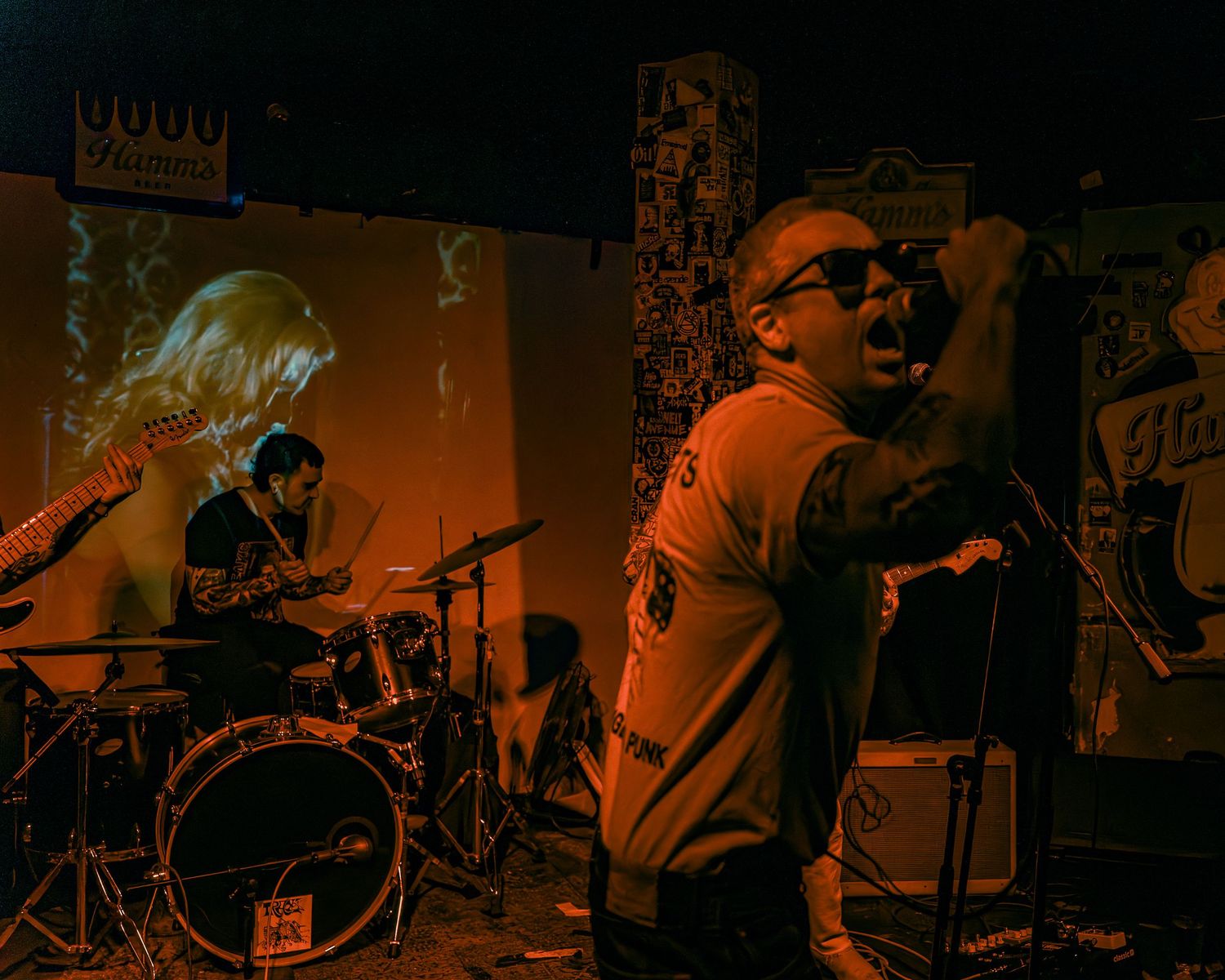 Concert footage captured in warm orange stage lighting showing energetic performance.