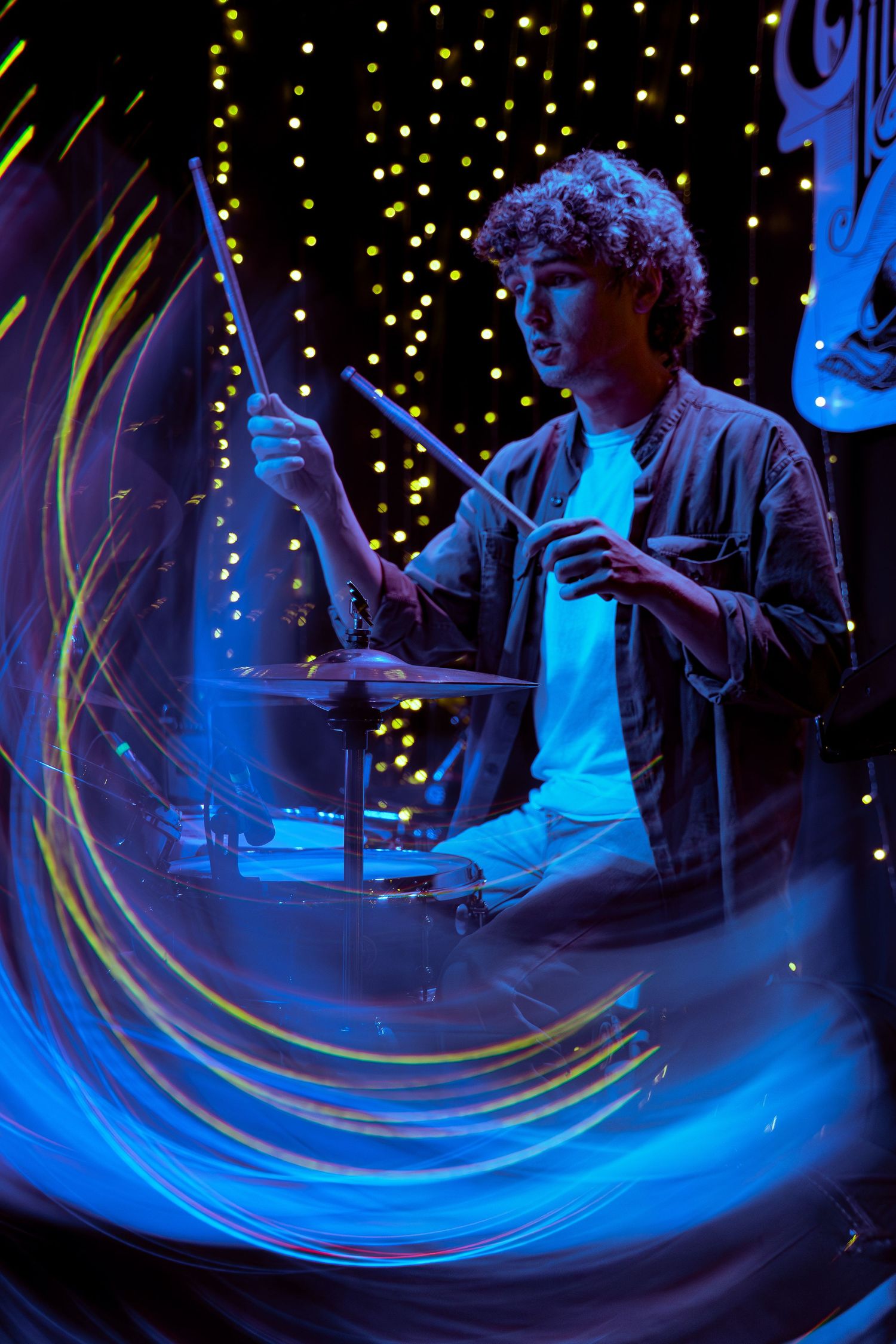 Light painting with swirling blue and yellow streaks creates a dynamic long exposure effect against a starry background.