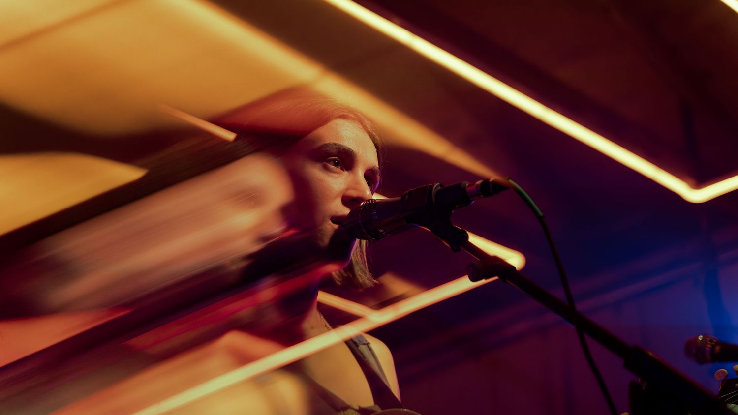 Motion-blurred collage in warm orange tones showing abstract diagonal lights and movement patterns.