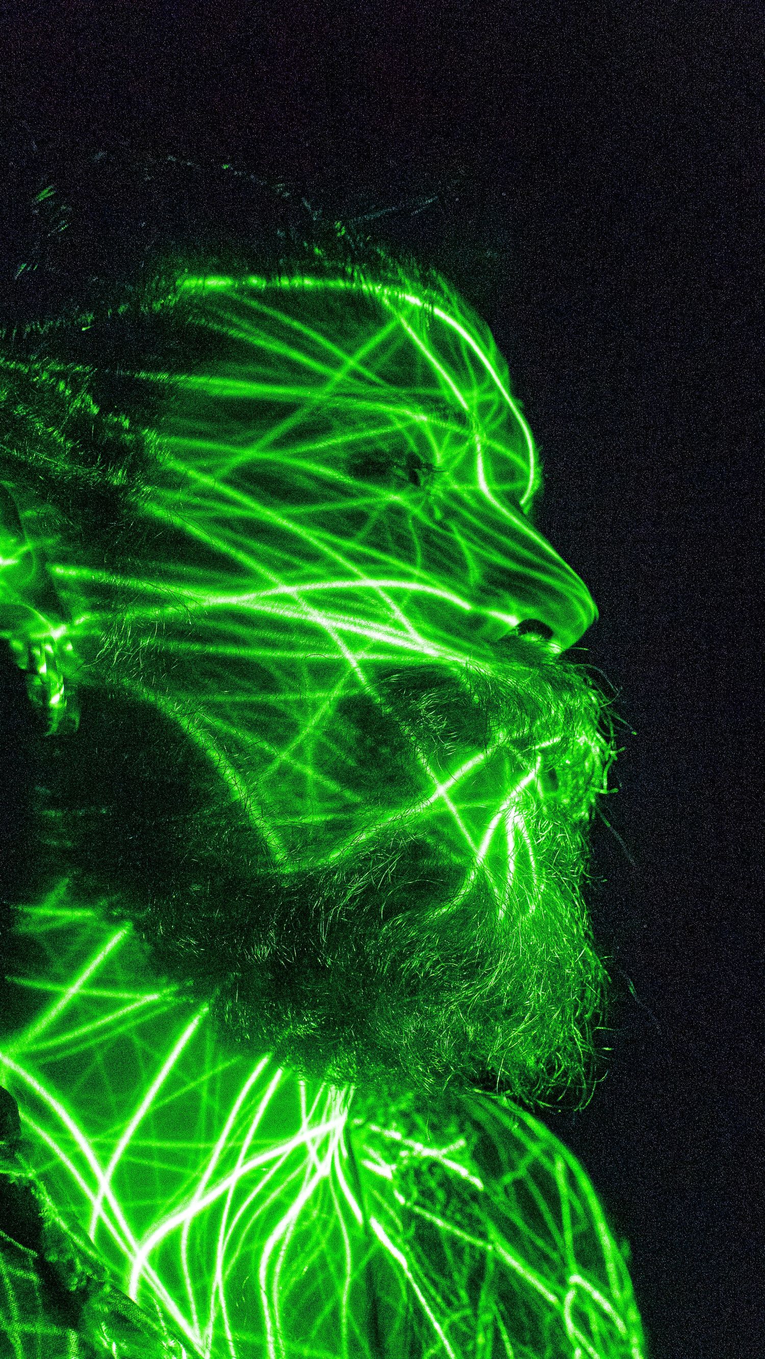 Abstract light painting in neon green creates ethereal patterns against black background.
