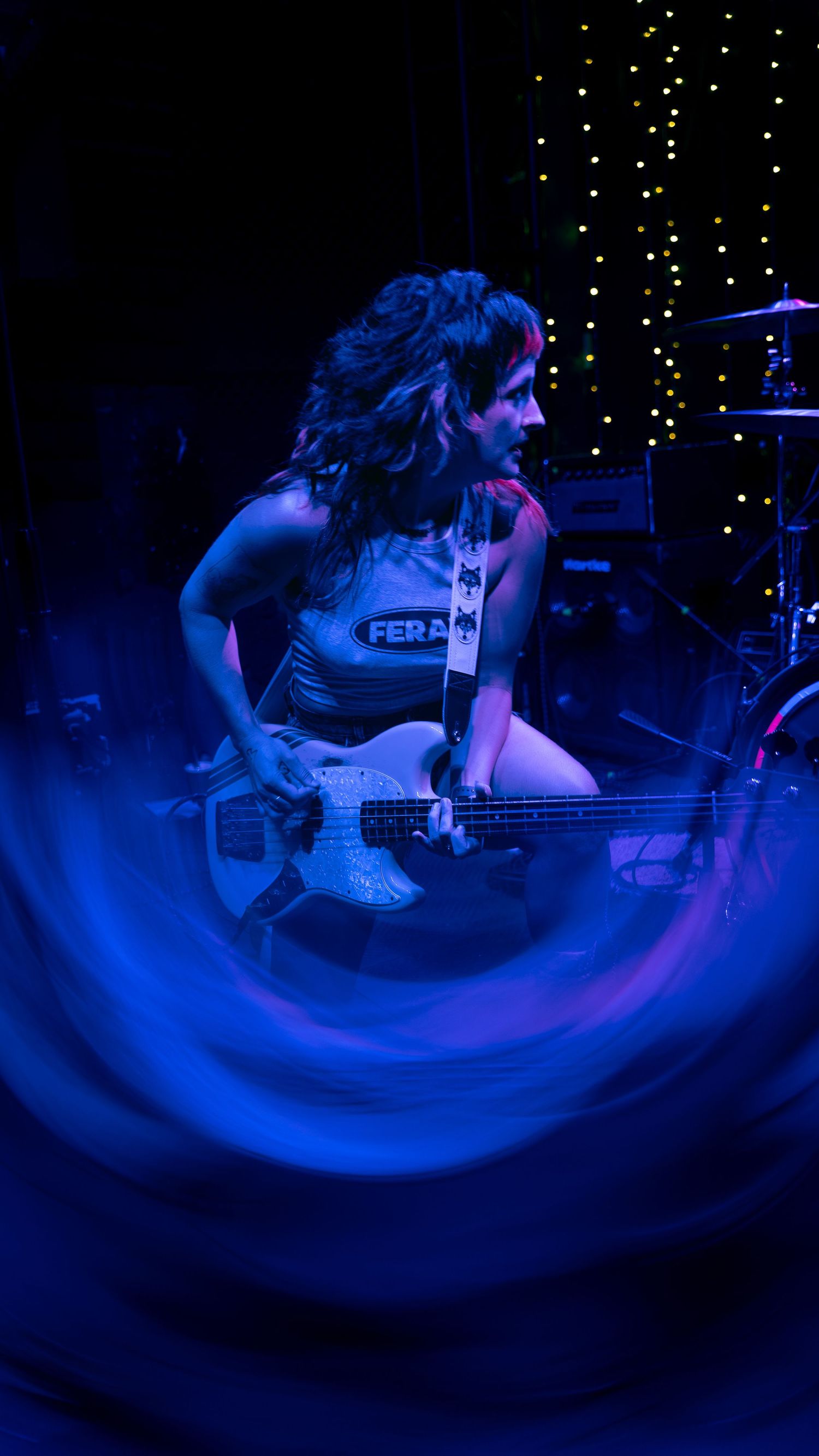 Performance art sequence showing spinning movement under dramatic blue stage lighting and twinkling background.
