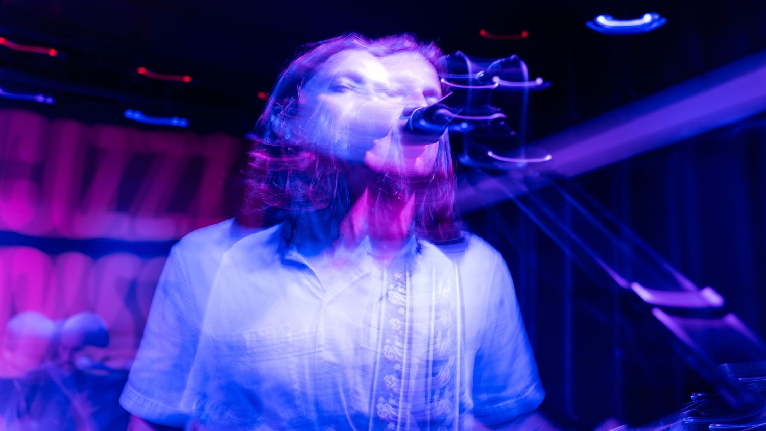 Stage performance captured under blue and purple theatrical lighting effects.