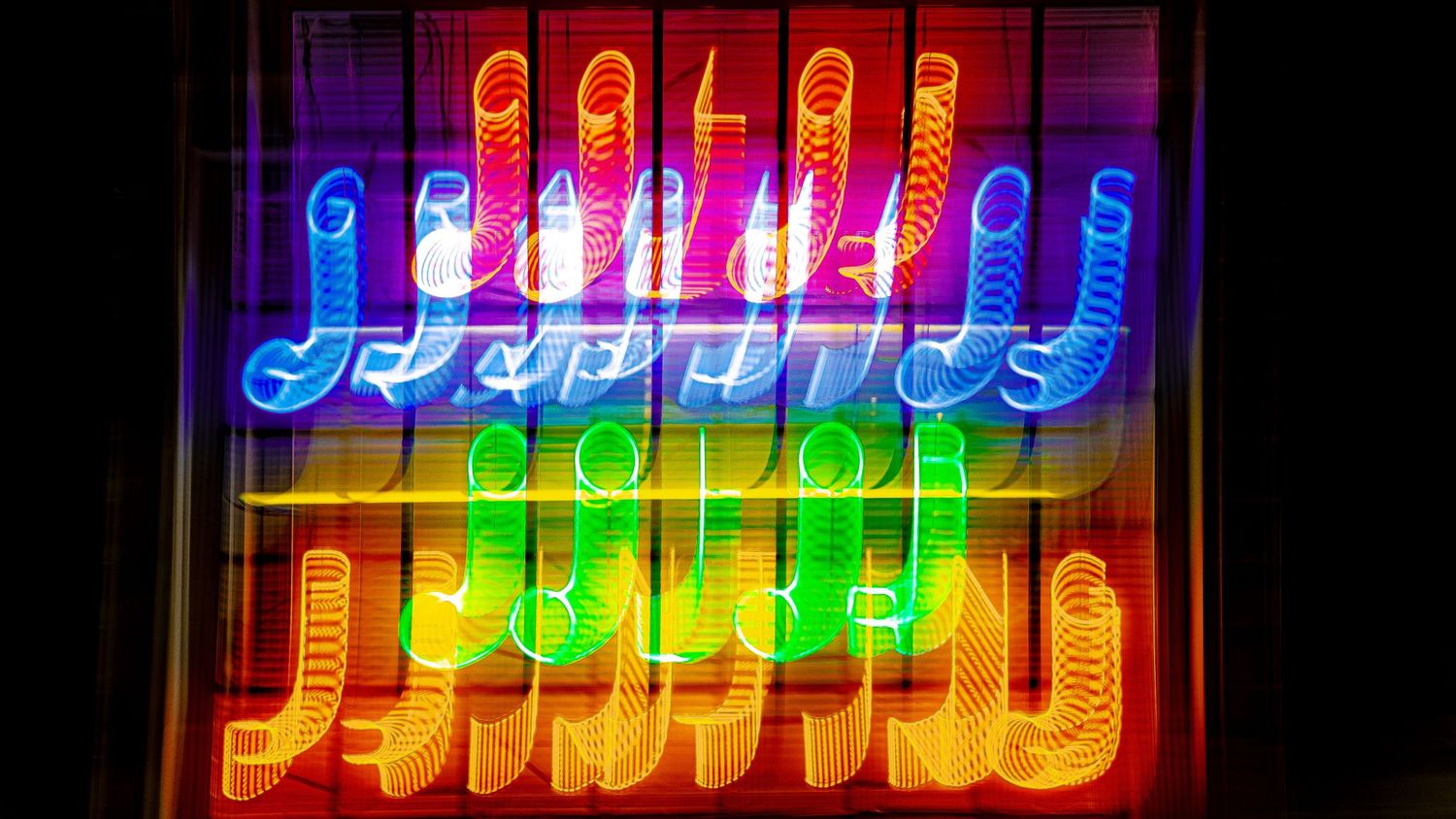 Colorful neon sign sequence displaying text in red and blue lighting.