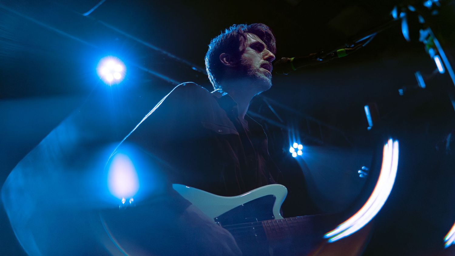 A blue-tinted concert scene features a crowd and stage lights creating an atmospheric live performance environment.