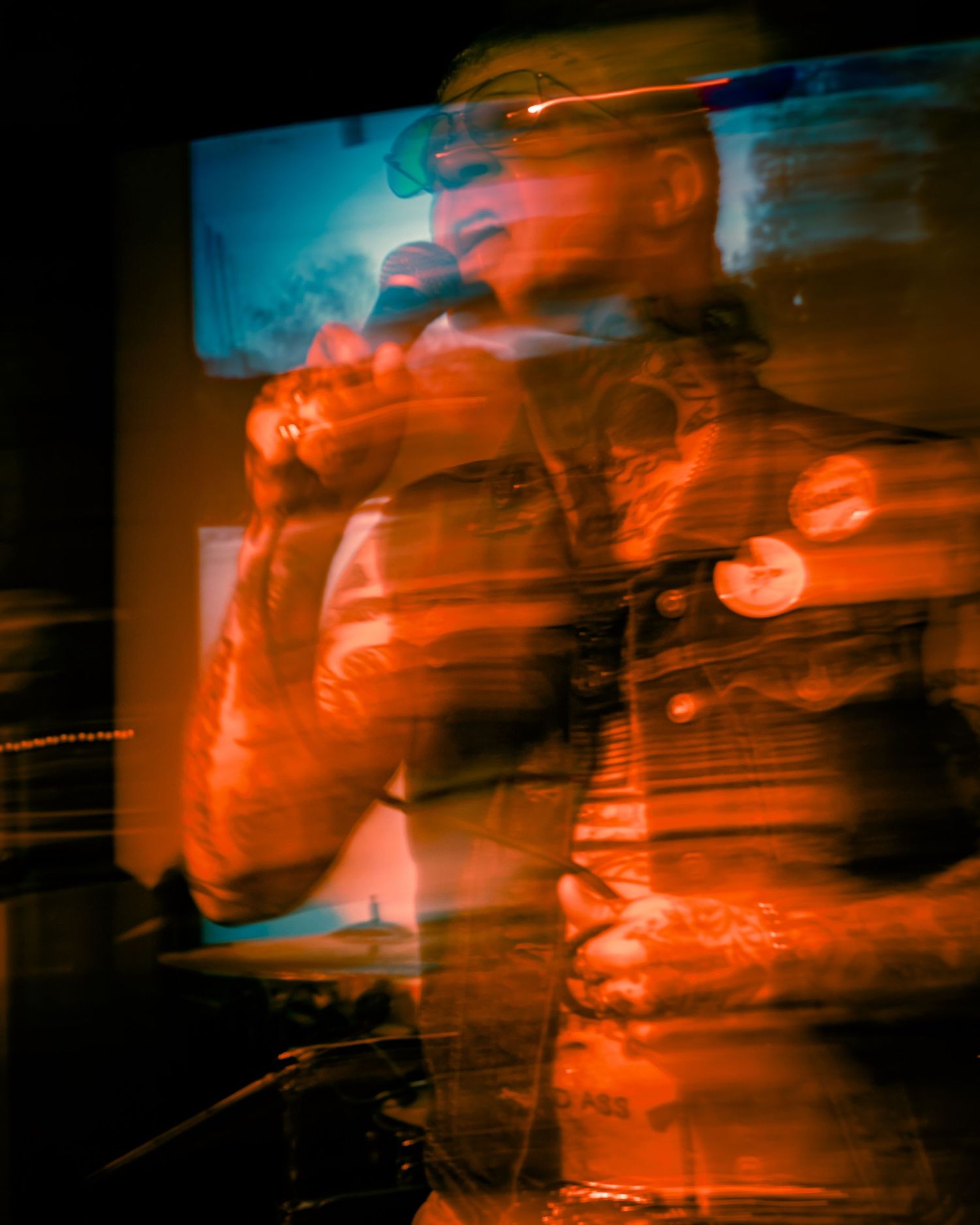 Abstract concert photo with double exposure effect in orange and red tones.