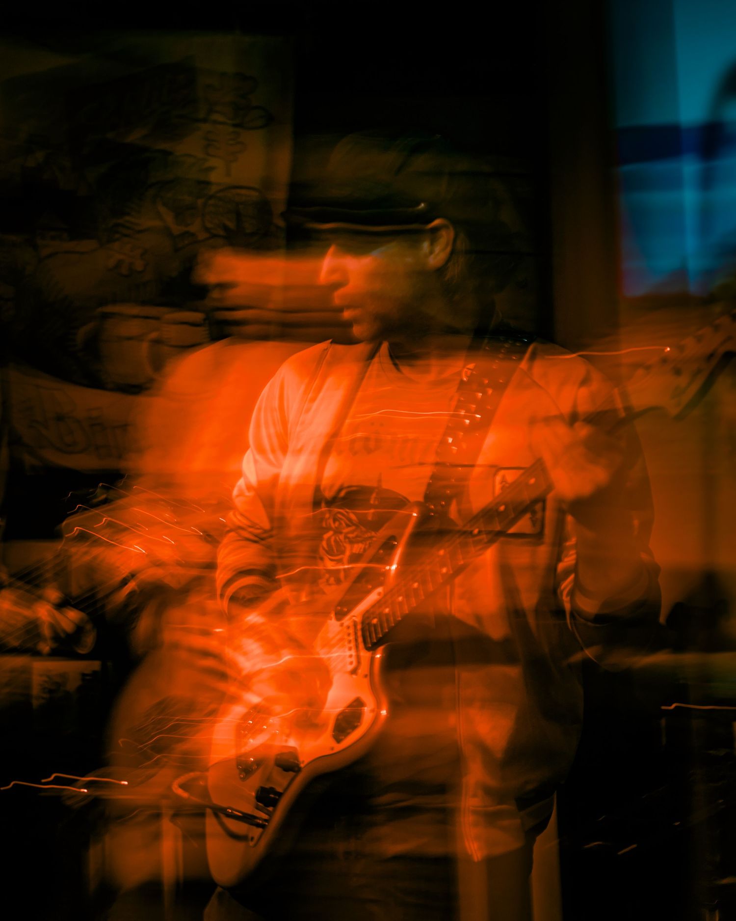 Abstract orange light trails against dark background creating ghostly performance imagery.