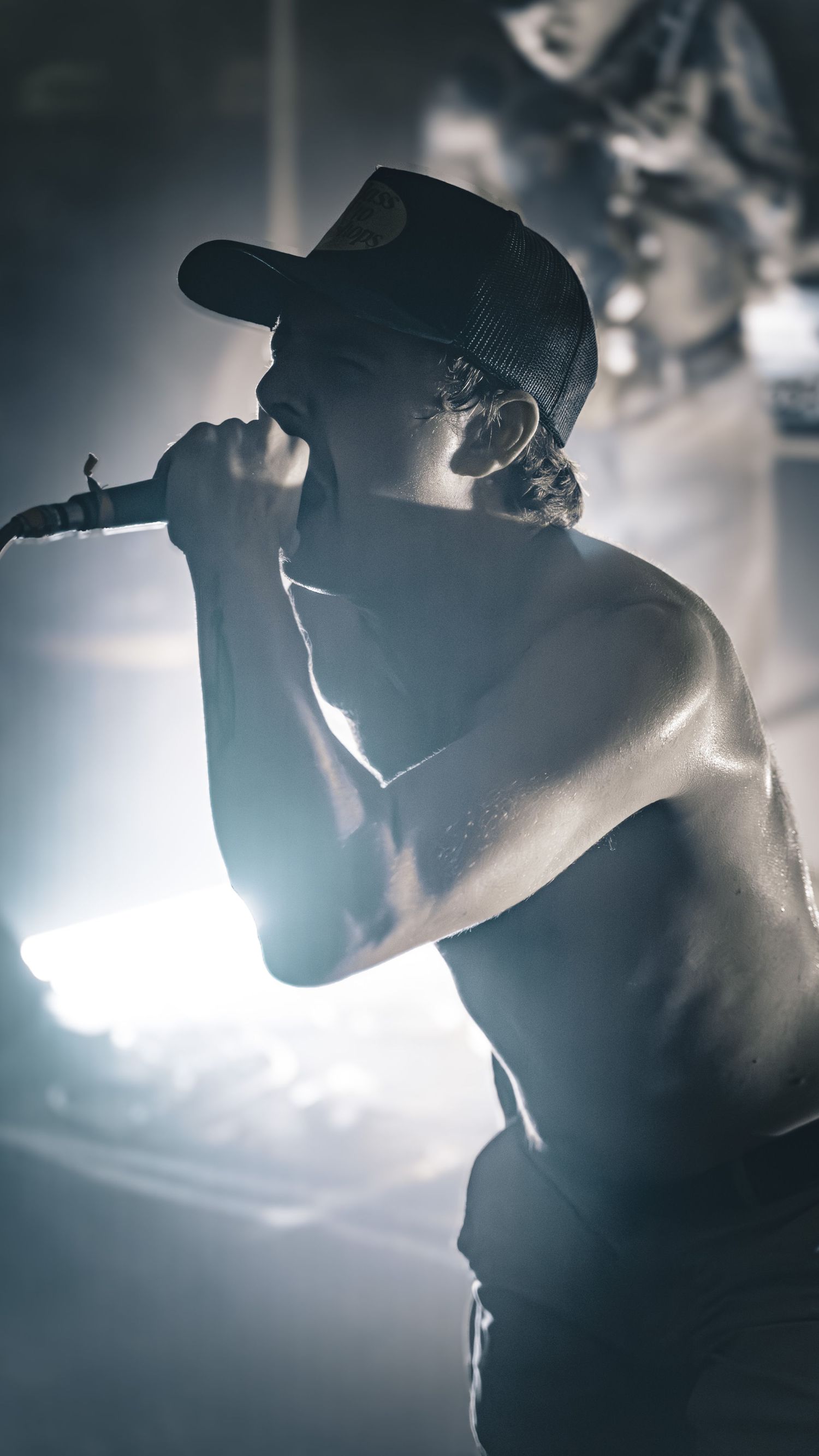 Silhouetted performer in front of bright stage lights creates dramatic backlighting effect.