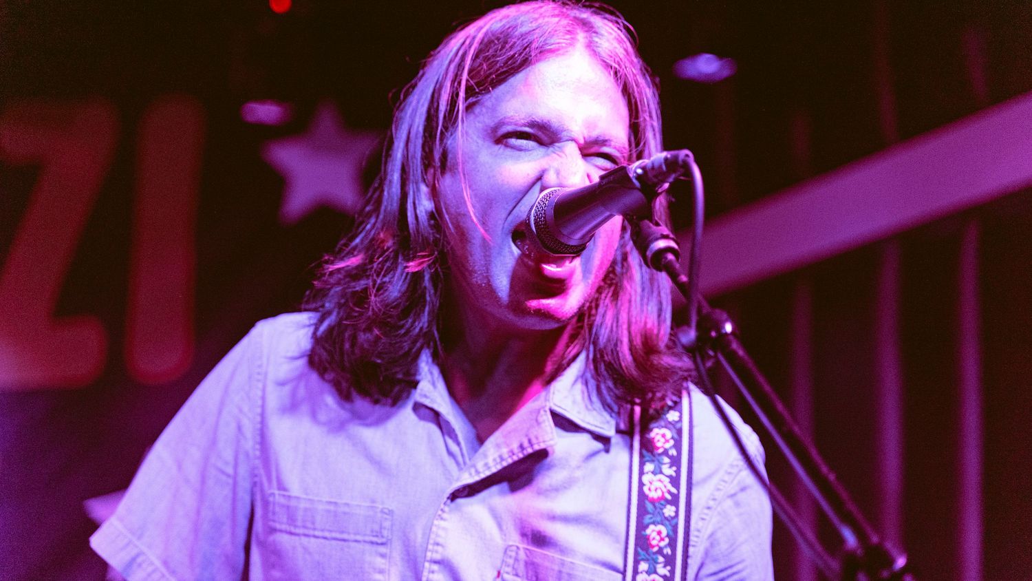 Concert imagery bathed in vibrant purple stage lighting creating atmospheric mood.