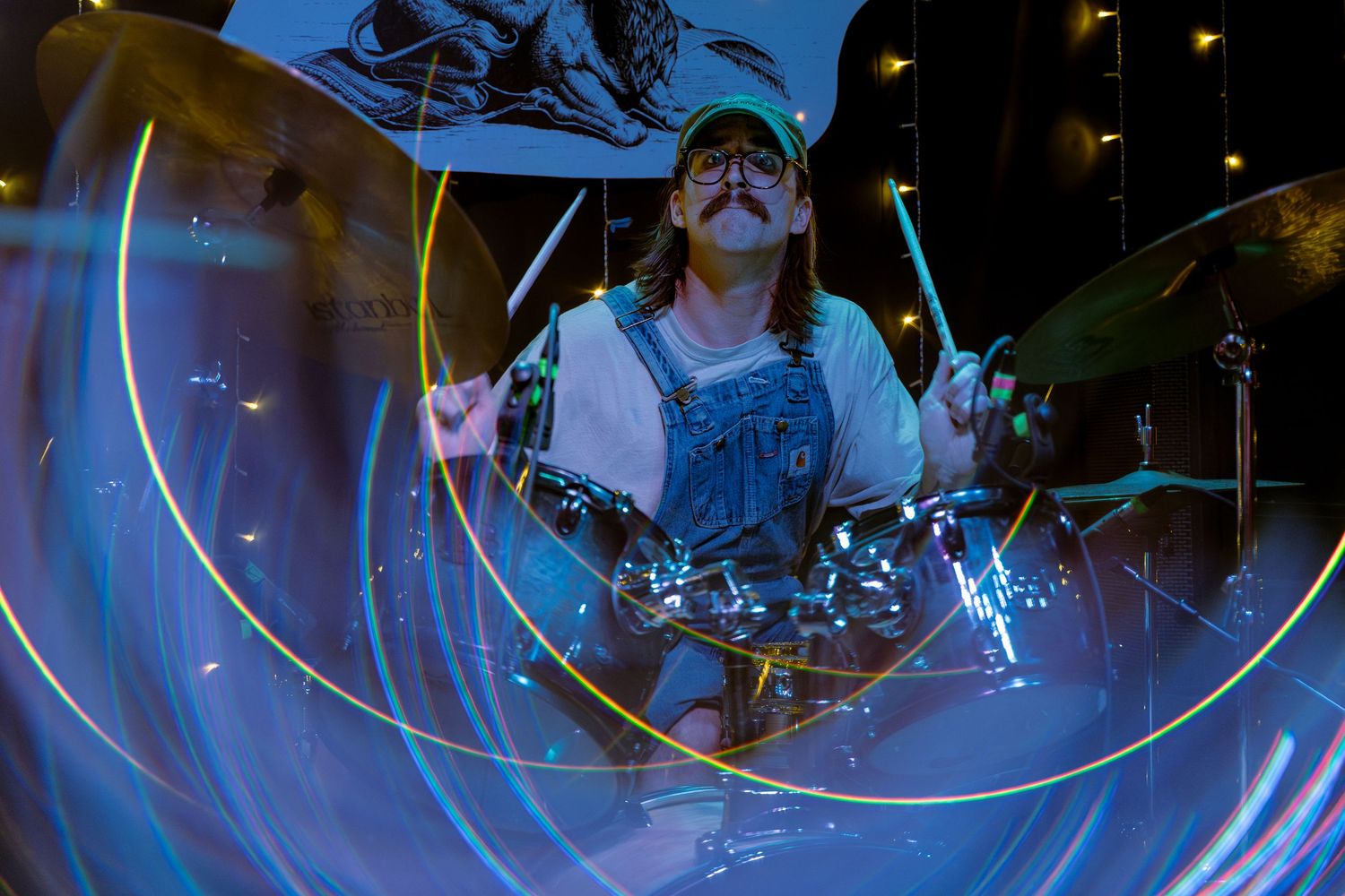 Light trails create glowing spiral patterns against a dark blue background in a long exposure photograph.