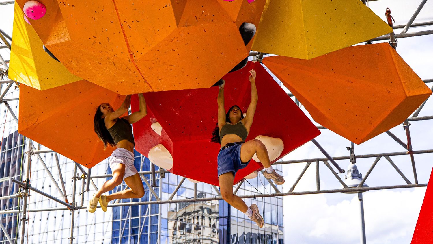 Decorative orange and yellow umbrellas hanging from metal framework creating a vibrant overhead display.