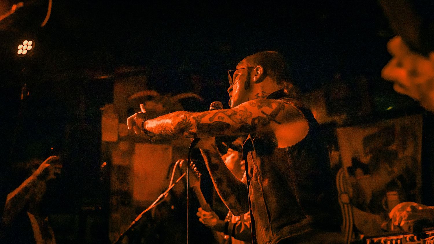 Dynamic stage performance captured in warm orange tones with dramatic lighting and crowd silhouettes.
