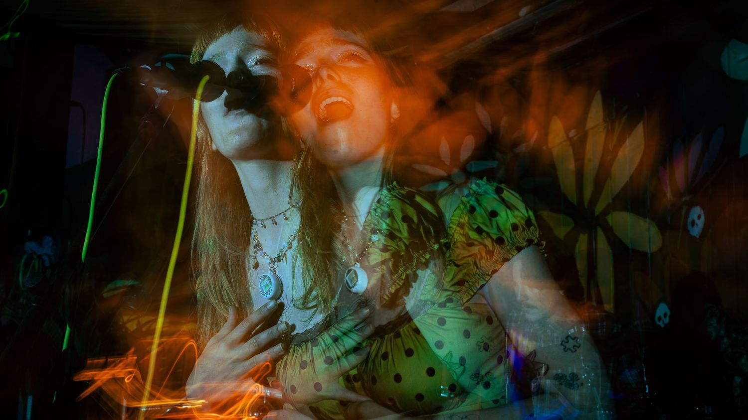 Artistic multiple exposure concert photo with overlapping colorful light trails.