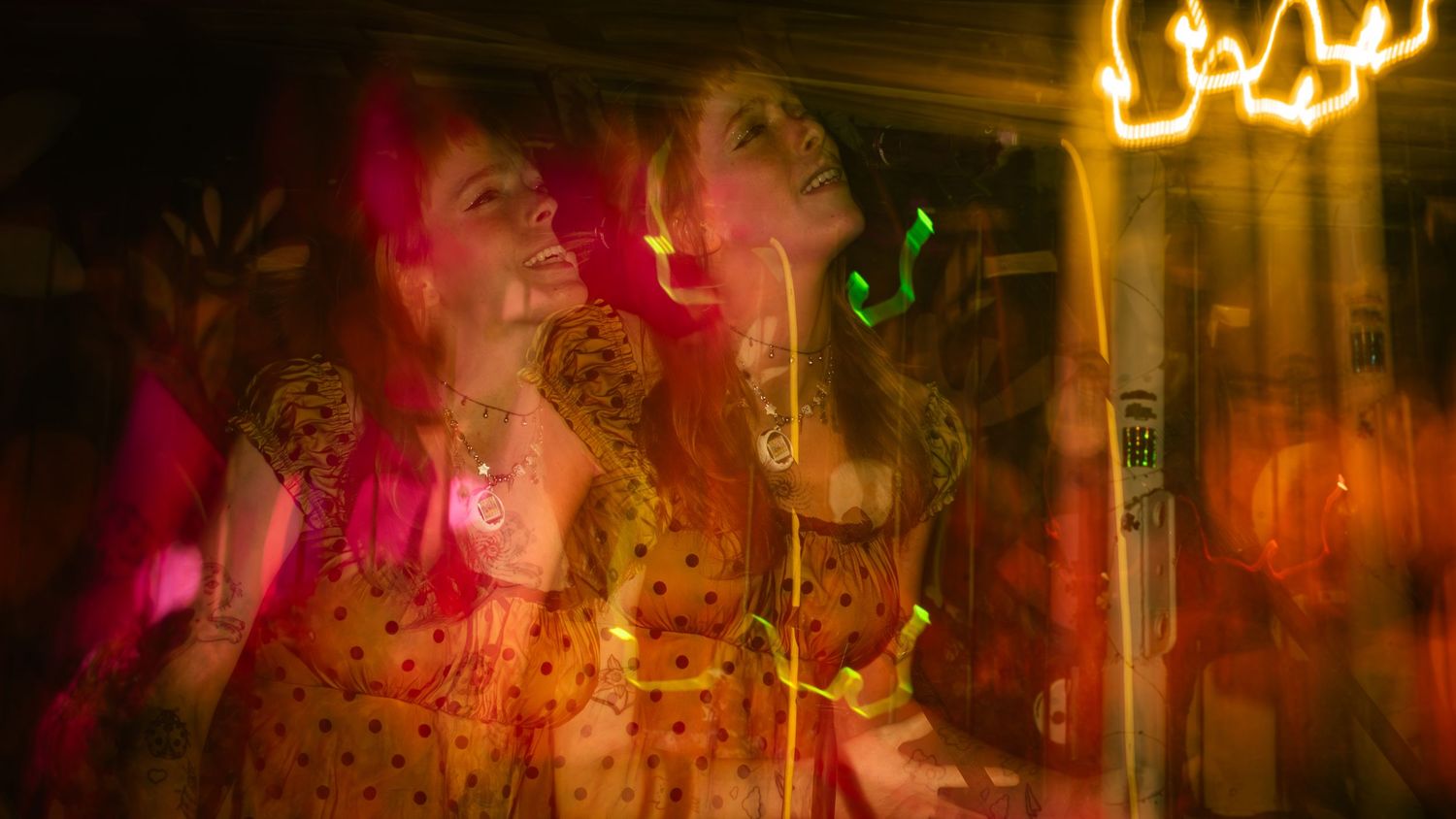 Double exposure concert photo with multiple overlapping images in red and pink tones.