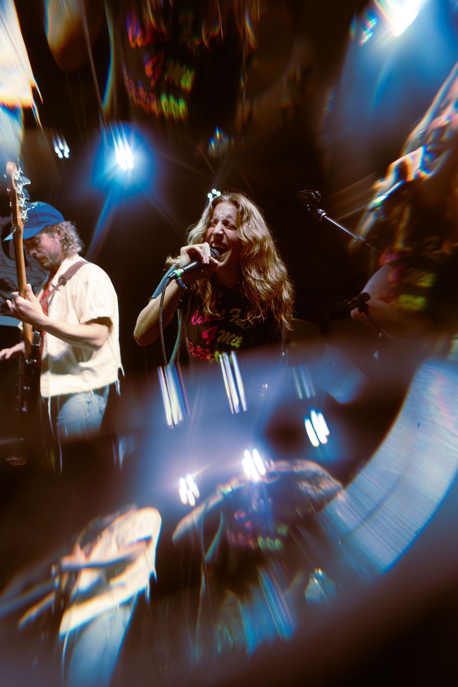 A band performs on stage with dramatic blue lighting and motion blur creating an atmospheric concert scene.