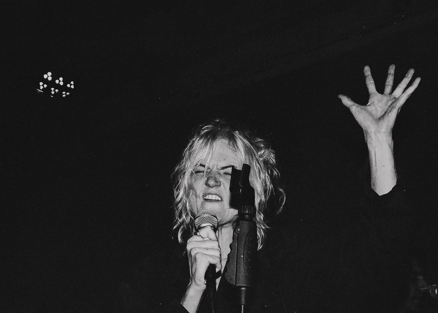 Live music performance in dramatic black and white lighting with intense stage presence.