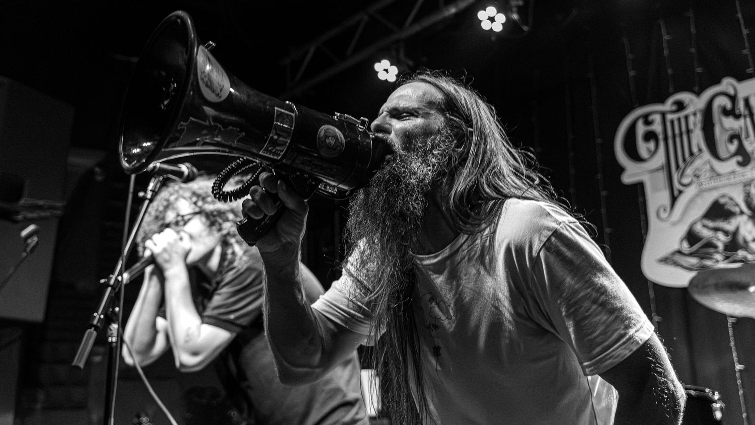 Black and white panoramic collage of musicians performing energetically on stage during a live concert.