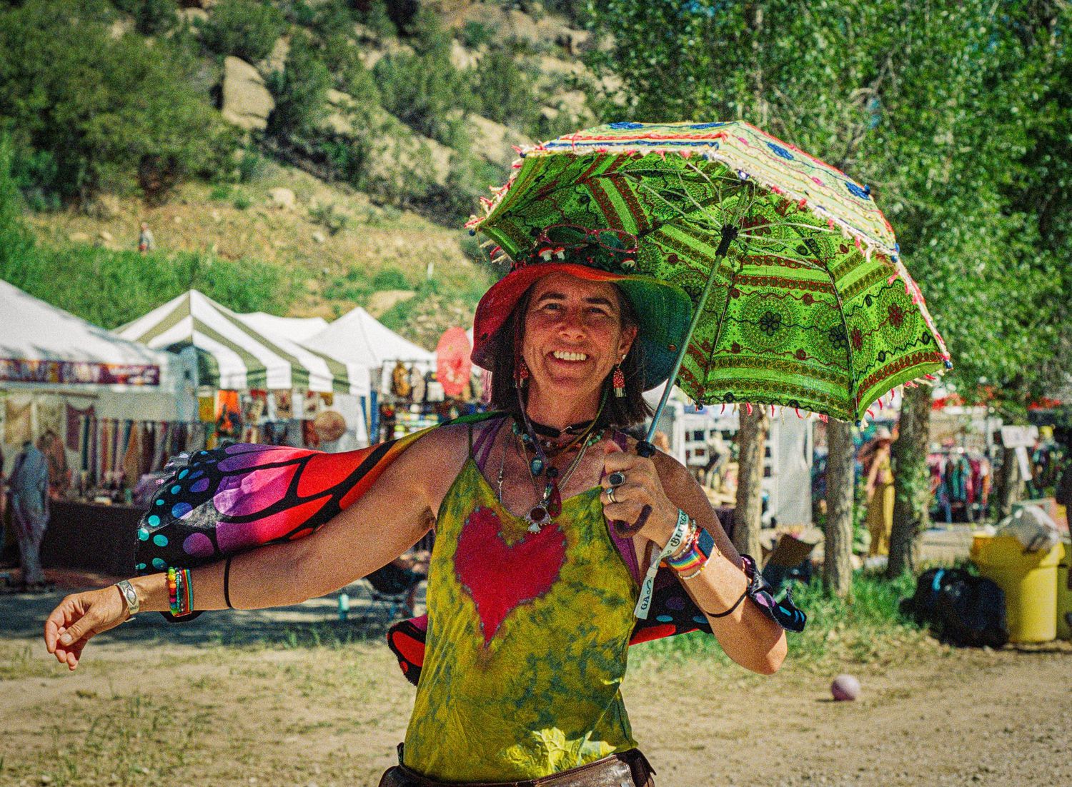 Festival goers enjoying outdoor activities in colorful clothing at a summer event.