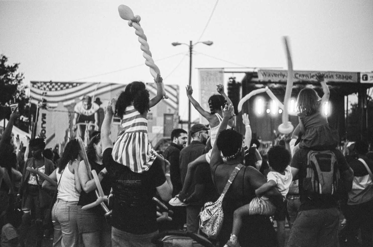 Black and white crowd scene at outdoor concert or rally with American flags.