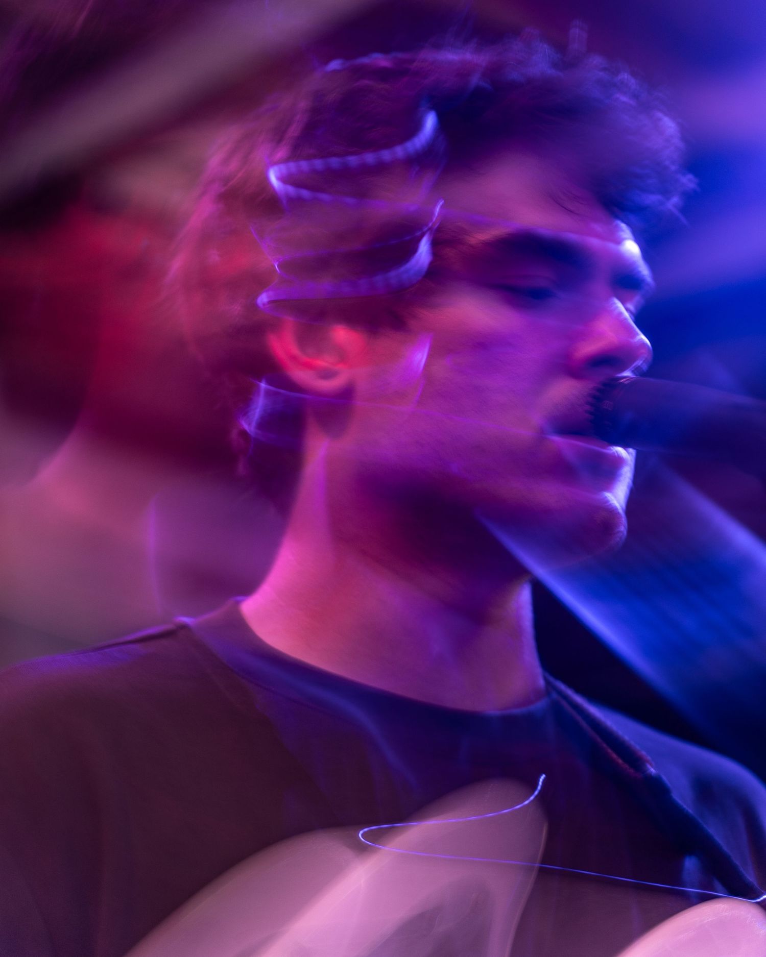Concert performance captured with purple lighting and motion blur effects.