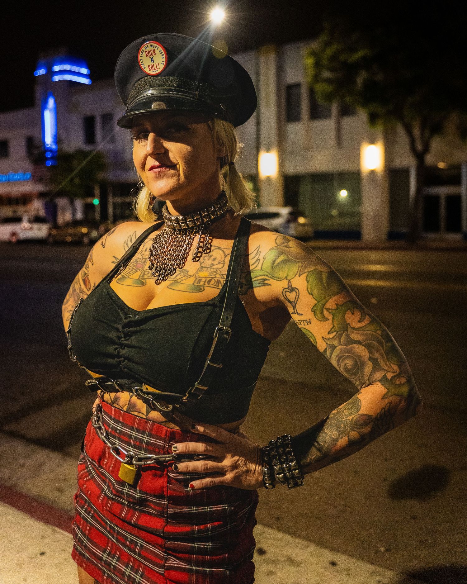 A portrait in streetwear and tattoos under night city lights.