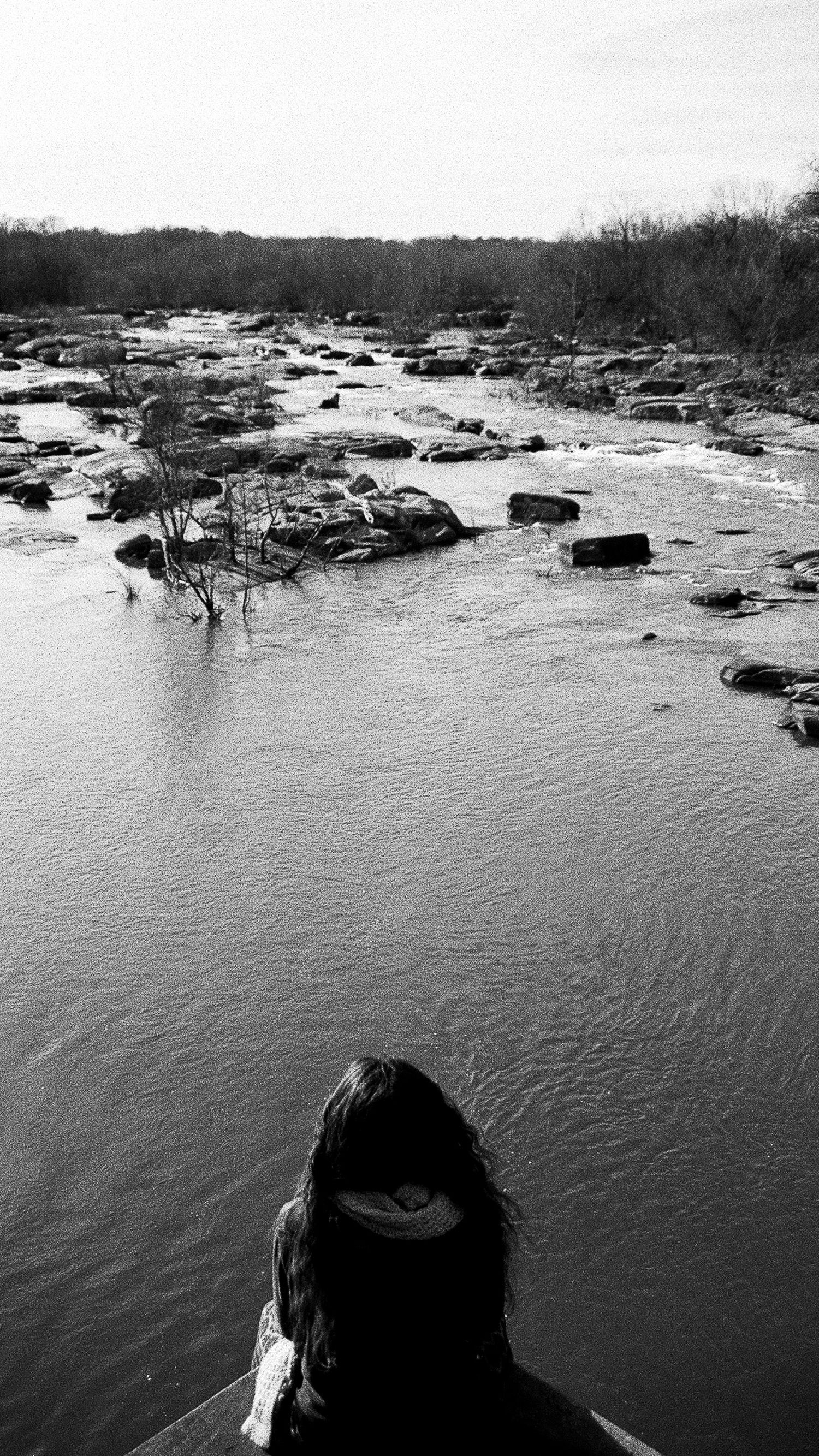 Rocky river landscape with flowing water and boulders viewed from above.