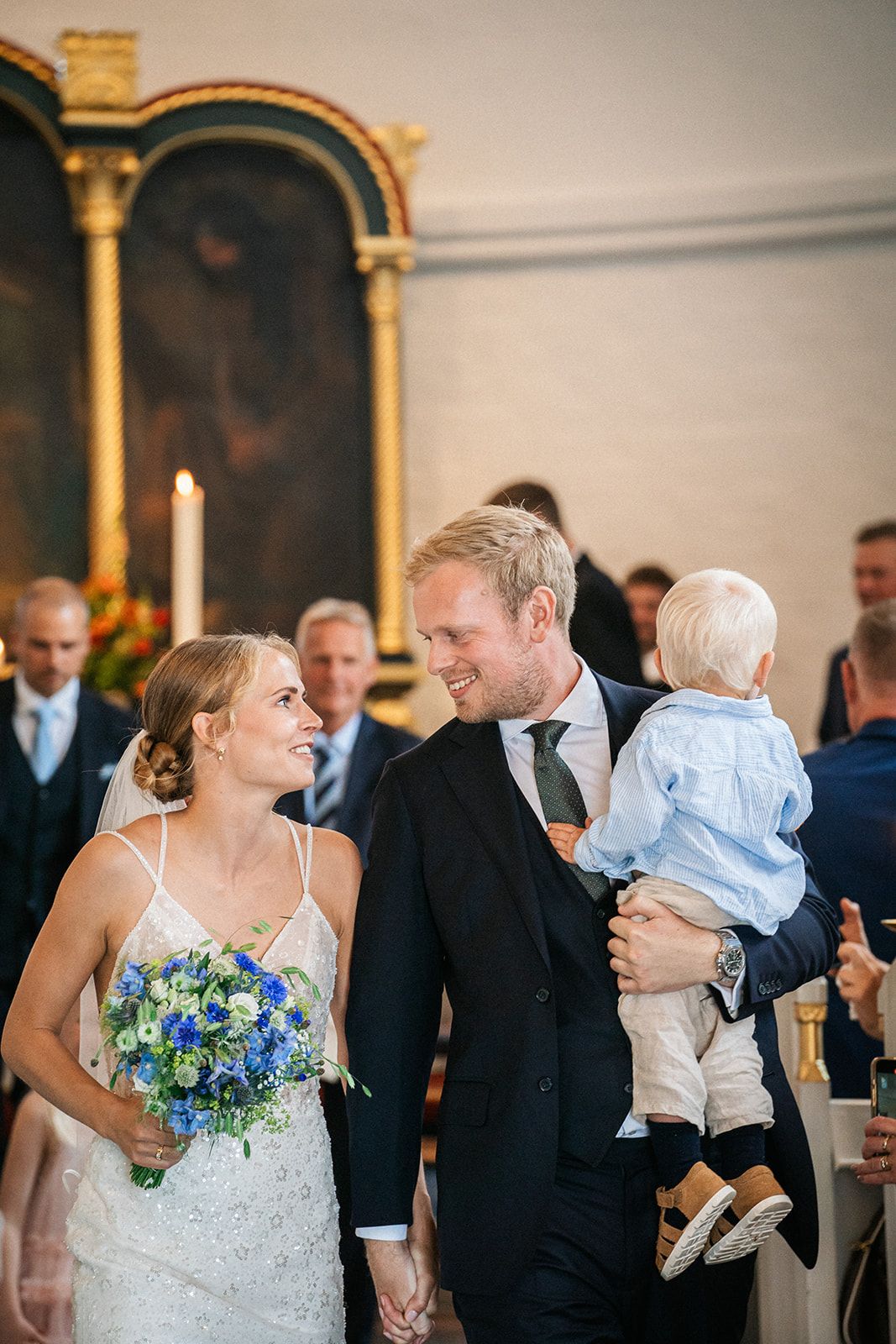 A series of candid wedding reception photos showing tender moments between couples and their baby in formal attire.