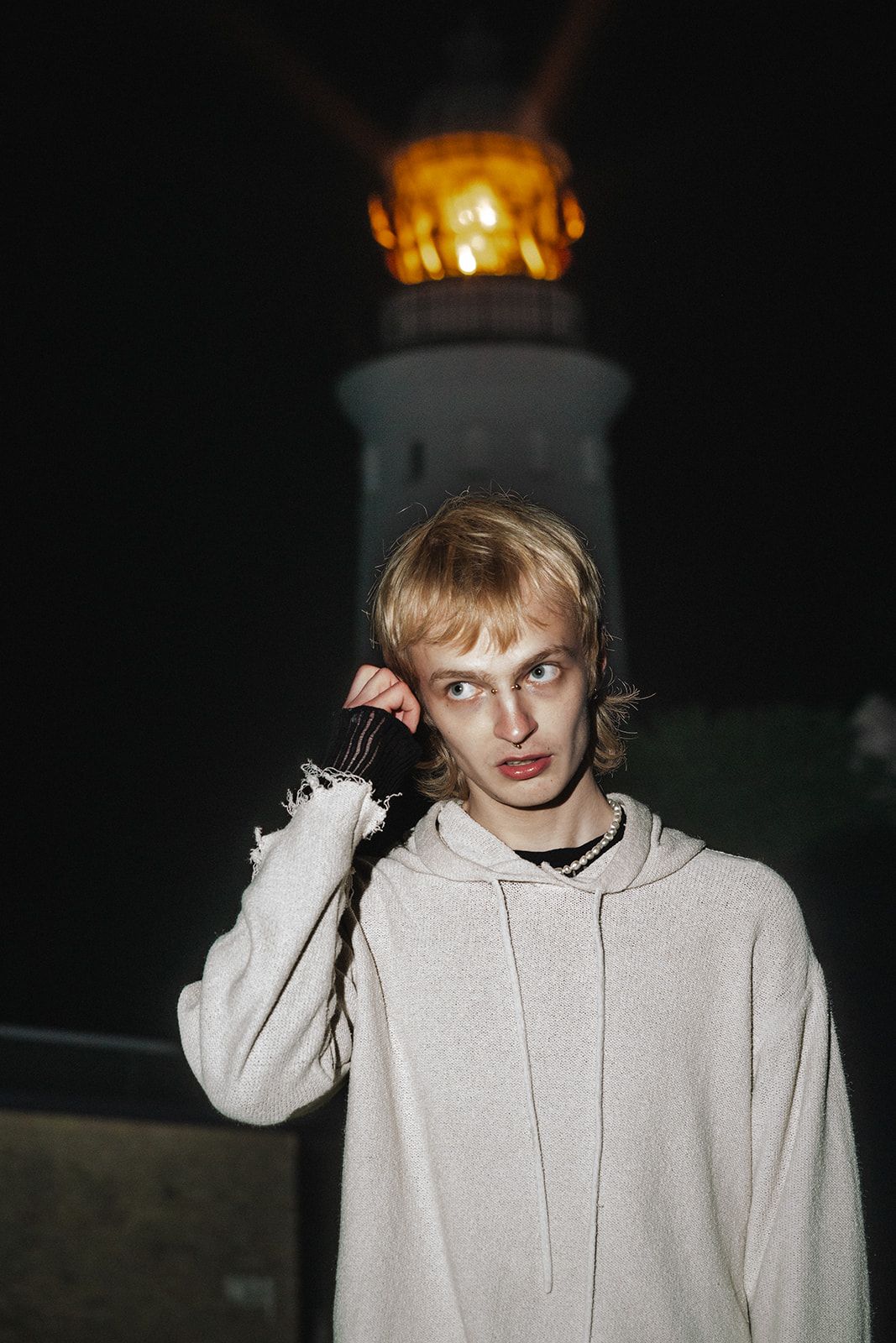 A series of photos showing someone in a light gray hoodie sweatshirt at night.