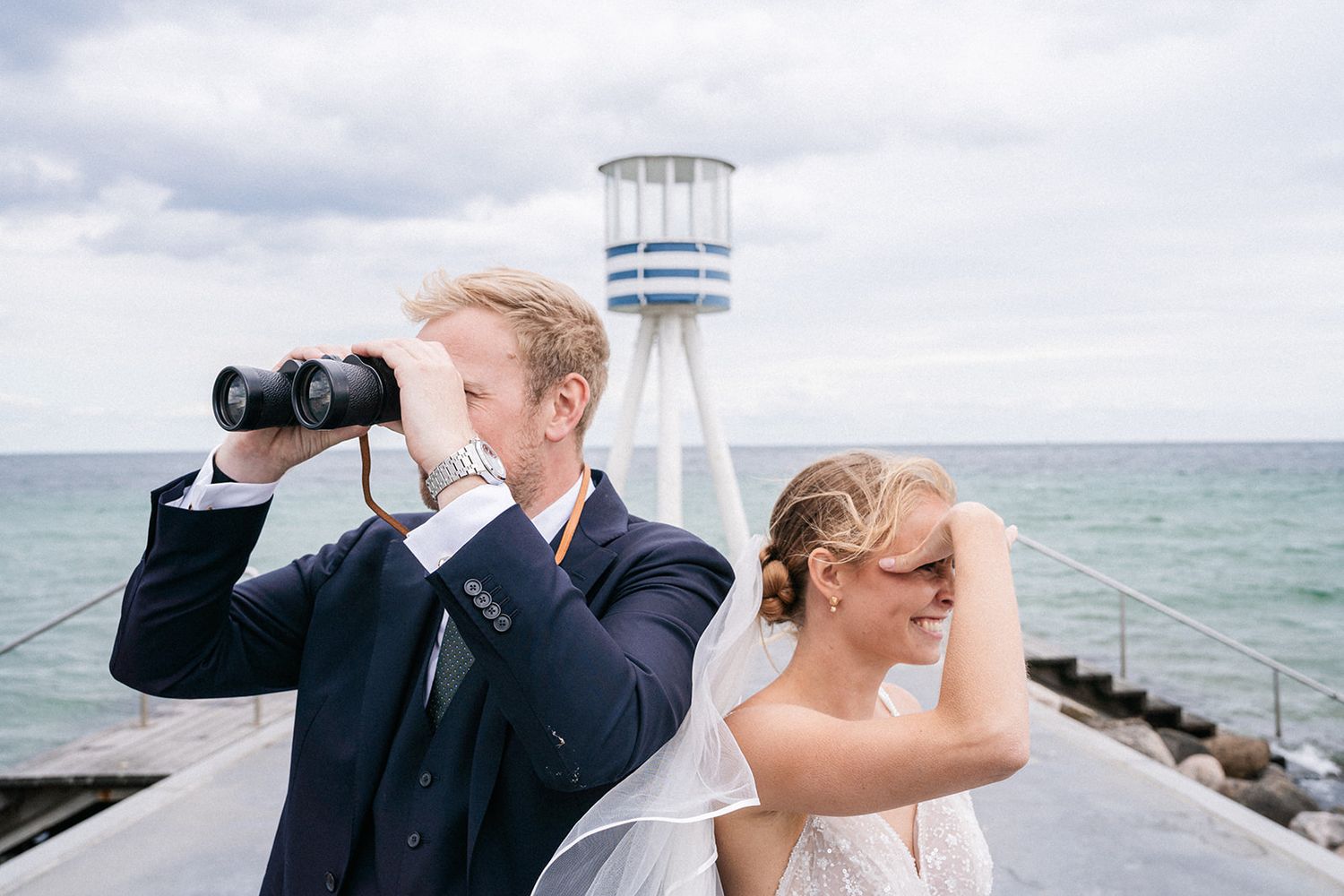 A scenic waterfront photo sequence showing a couple looking through binoculars at the ocean view.