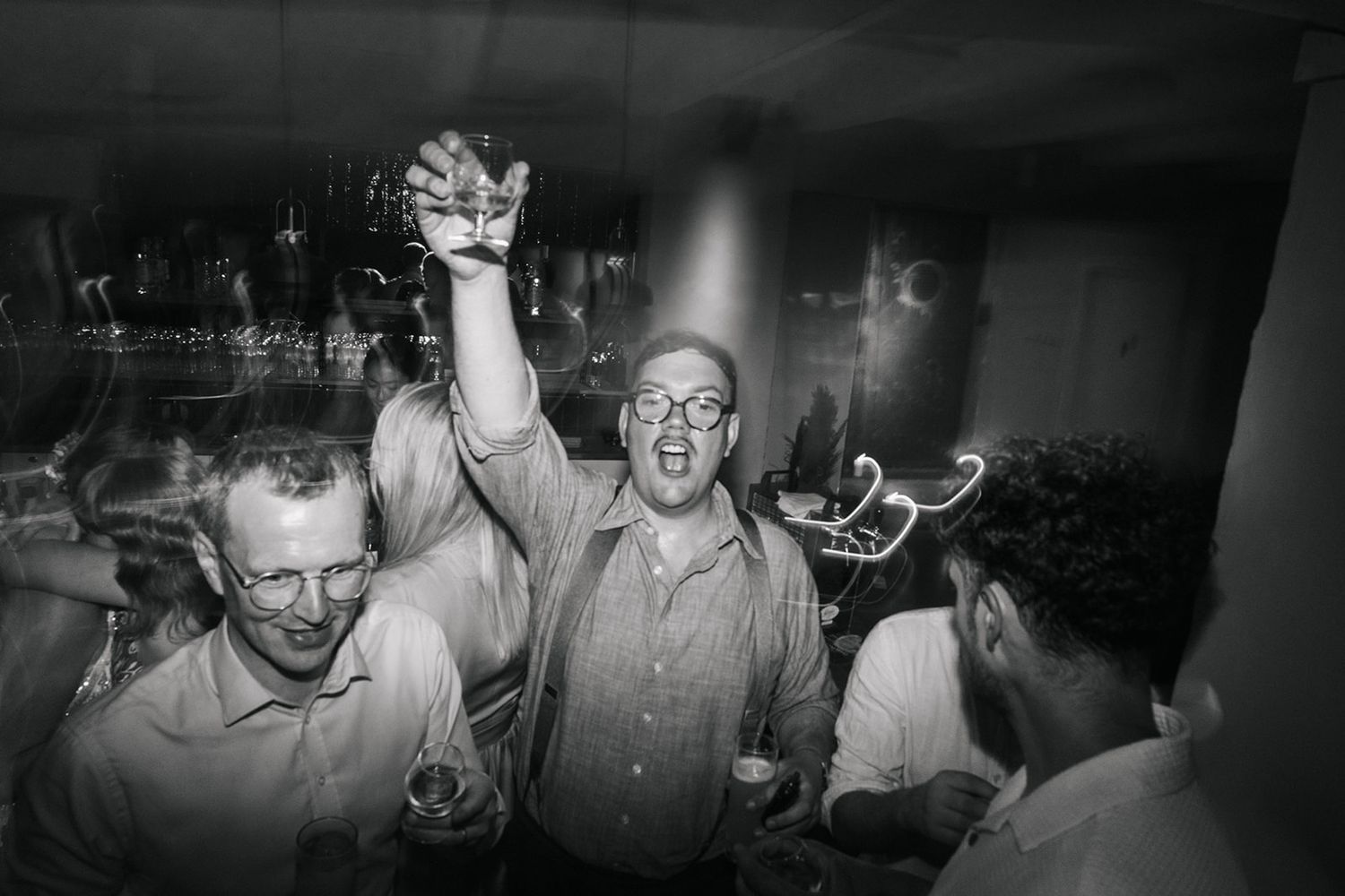 Black and white photograph shows six film stills of lively scenes from a vintage party or social gathering.