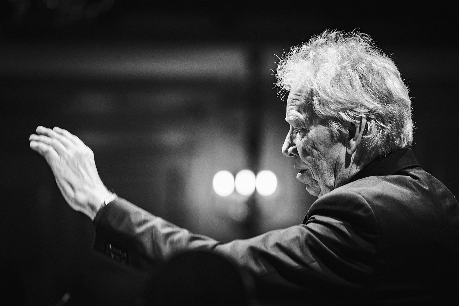 Black and white photo series showing someone conducting an orchestra with expressive hand gestures and movements.