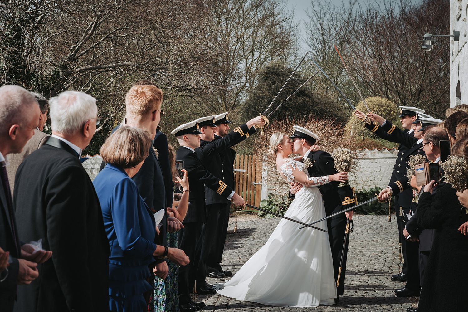 A collage of five candid outdoor wedding celebration moments showing guests socializing and dancing on a sunny day.